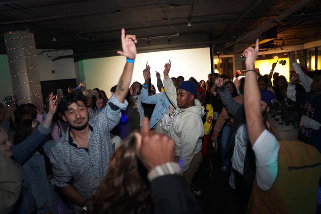 <p>Attendees at The Cove, an 18-and-up, pop-up Christian nightclub, dance in unison</p>