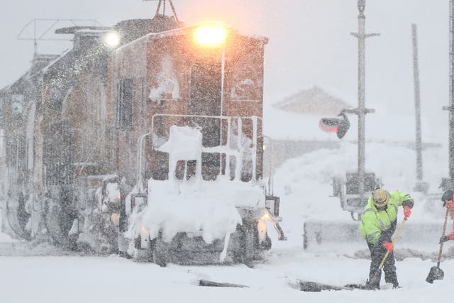 <p>Workers clear train tracks as snow falls north of Lake Tahoe in the Sierra Nevada mountains during a powerful winter storm on March 01, 2024 in Truckee, California</p>