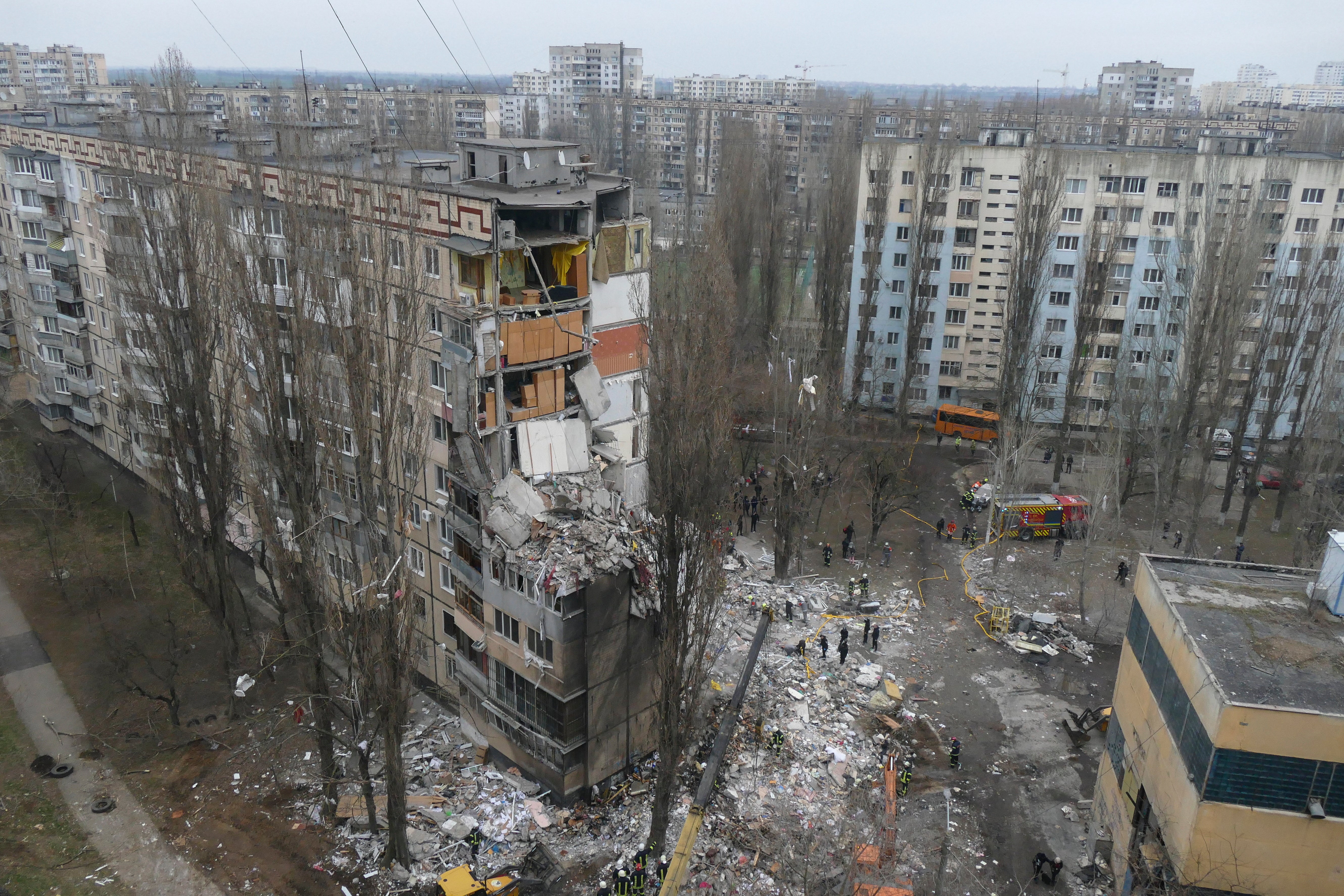 Ukrainian rescuers work on the site of a damaged residential building in Odesa after an overnight attack
