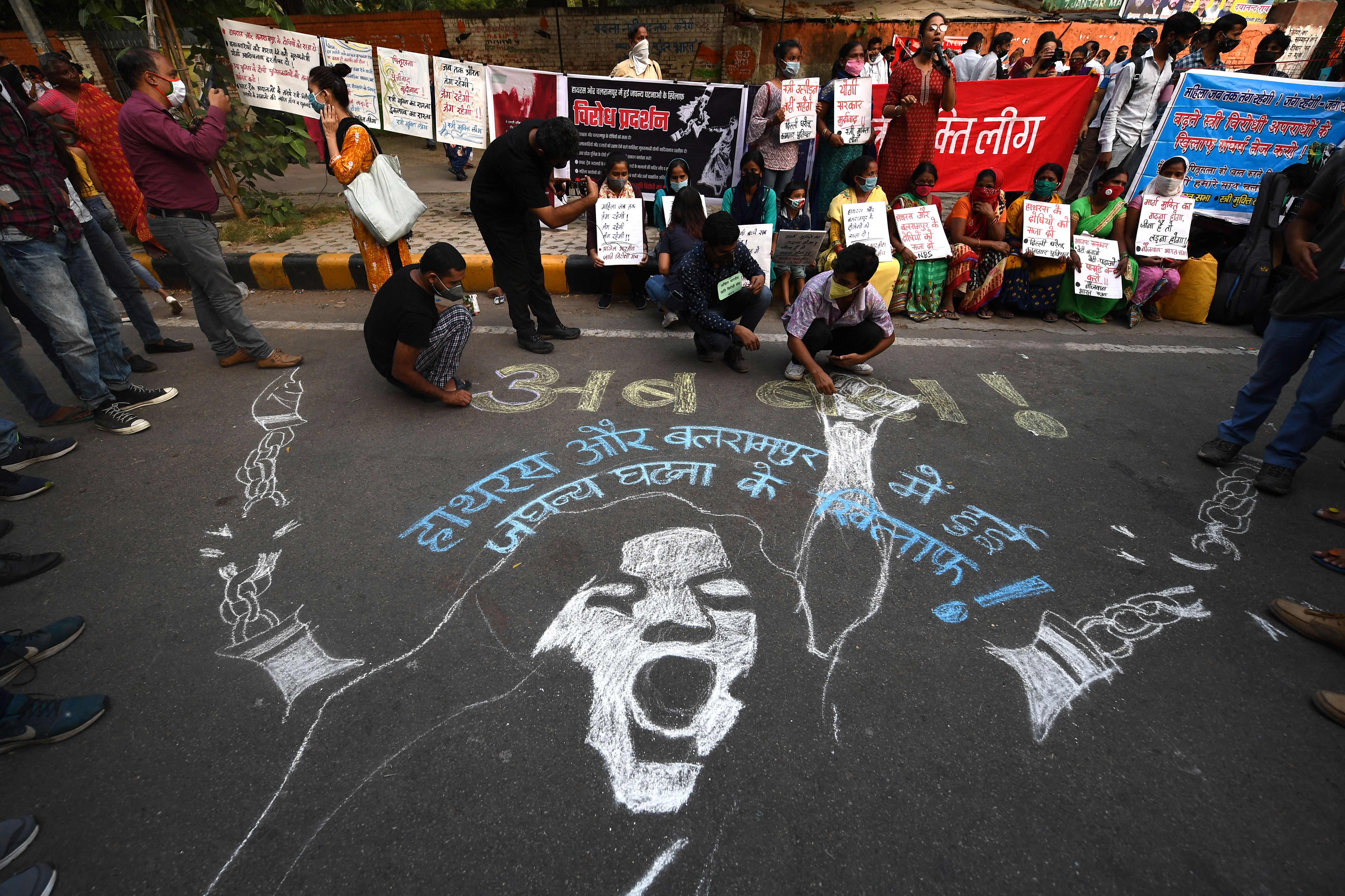 Demonstrators paint a floor mural to protest against rape in India
