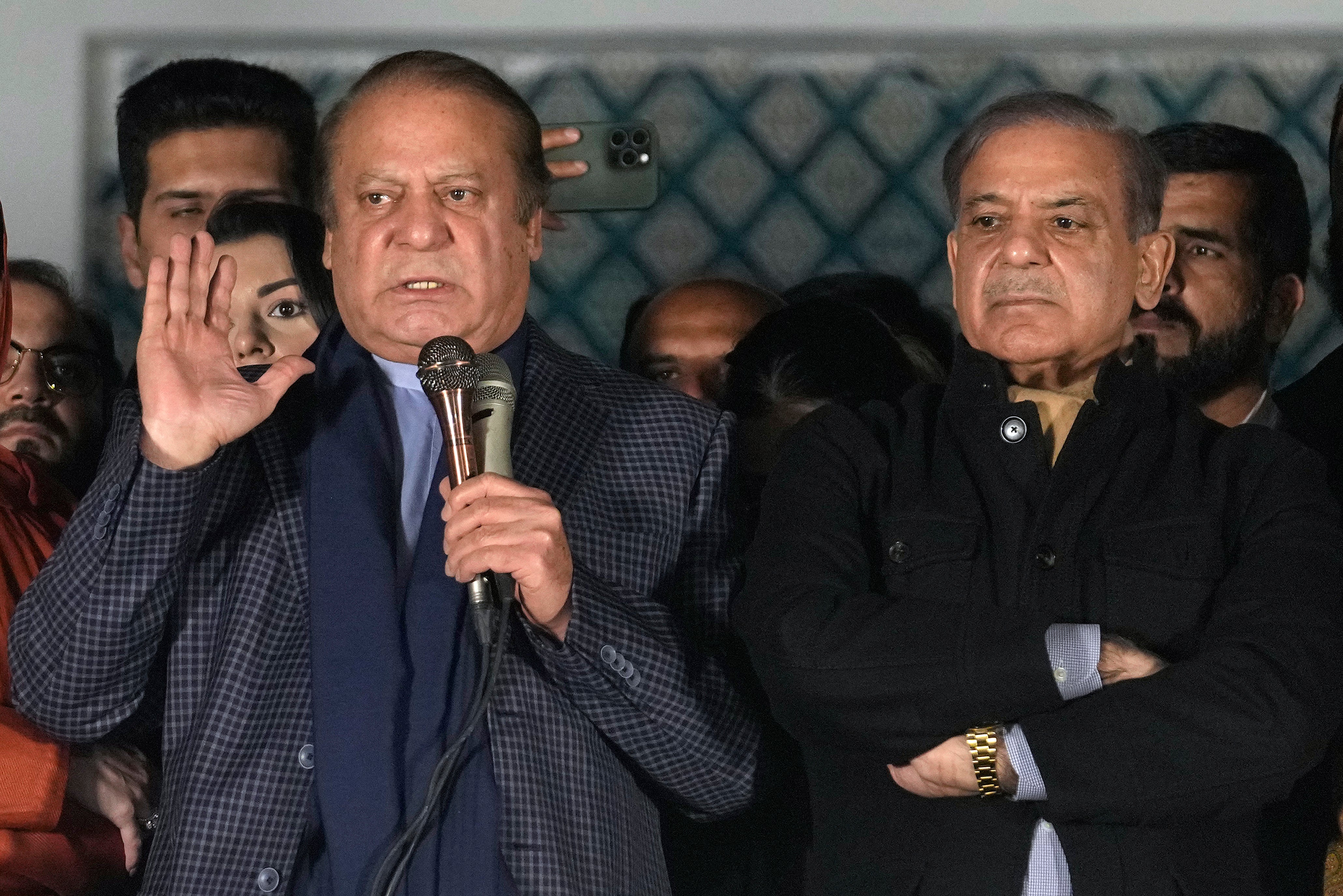 Pakistan’s former prime minister Nawaz Sharif, left, addresses supporters next to his newly-elected brother following initial results of the country's parliamentary election, in Lahore