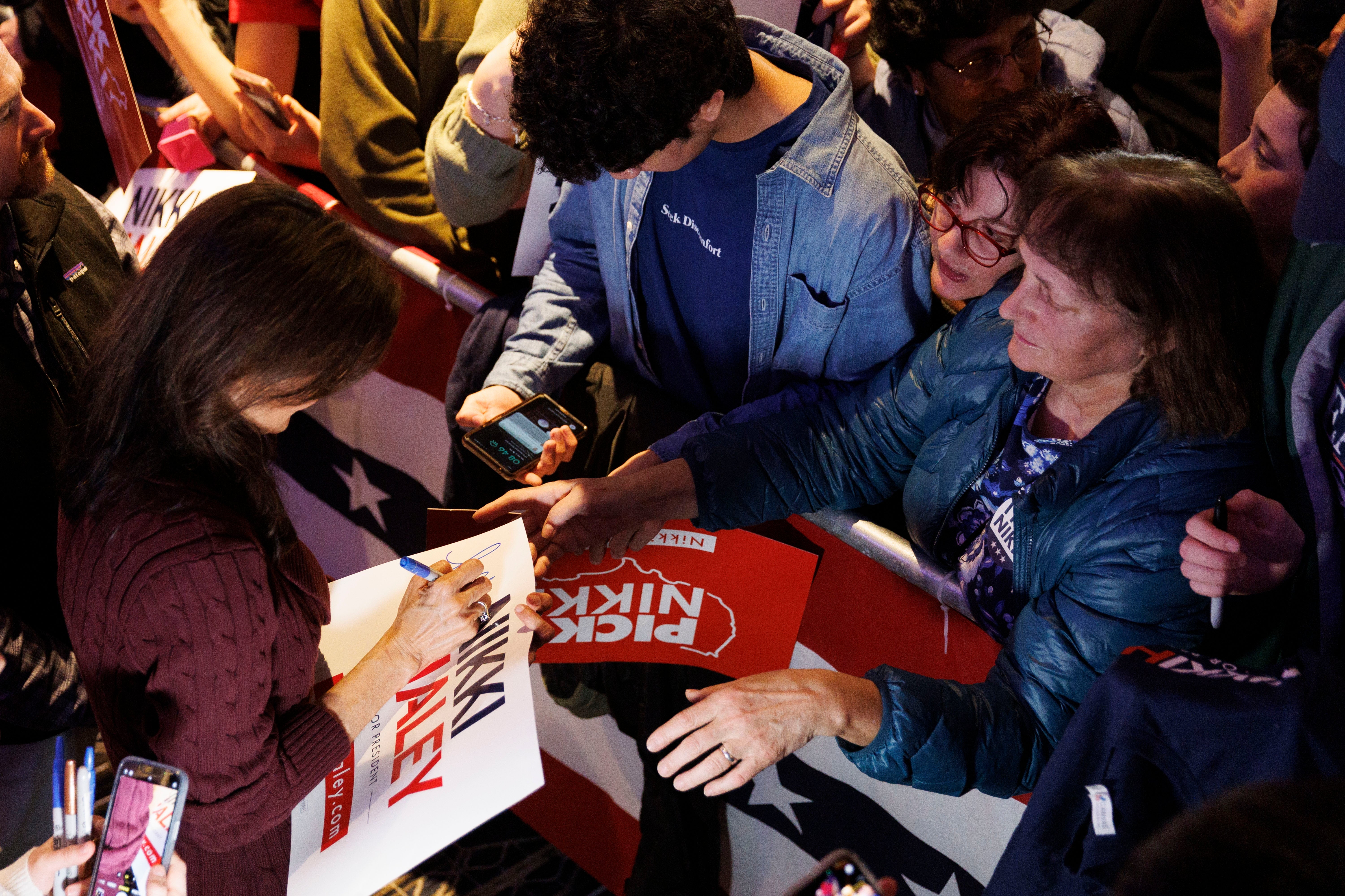 Republican US presidential candidate Nikki Haley (L) autographs a campaign placard during a campaign stop in Needham, Massachusetts, USA, 02 March 2024