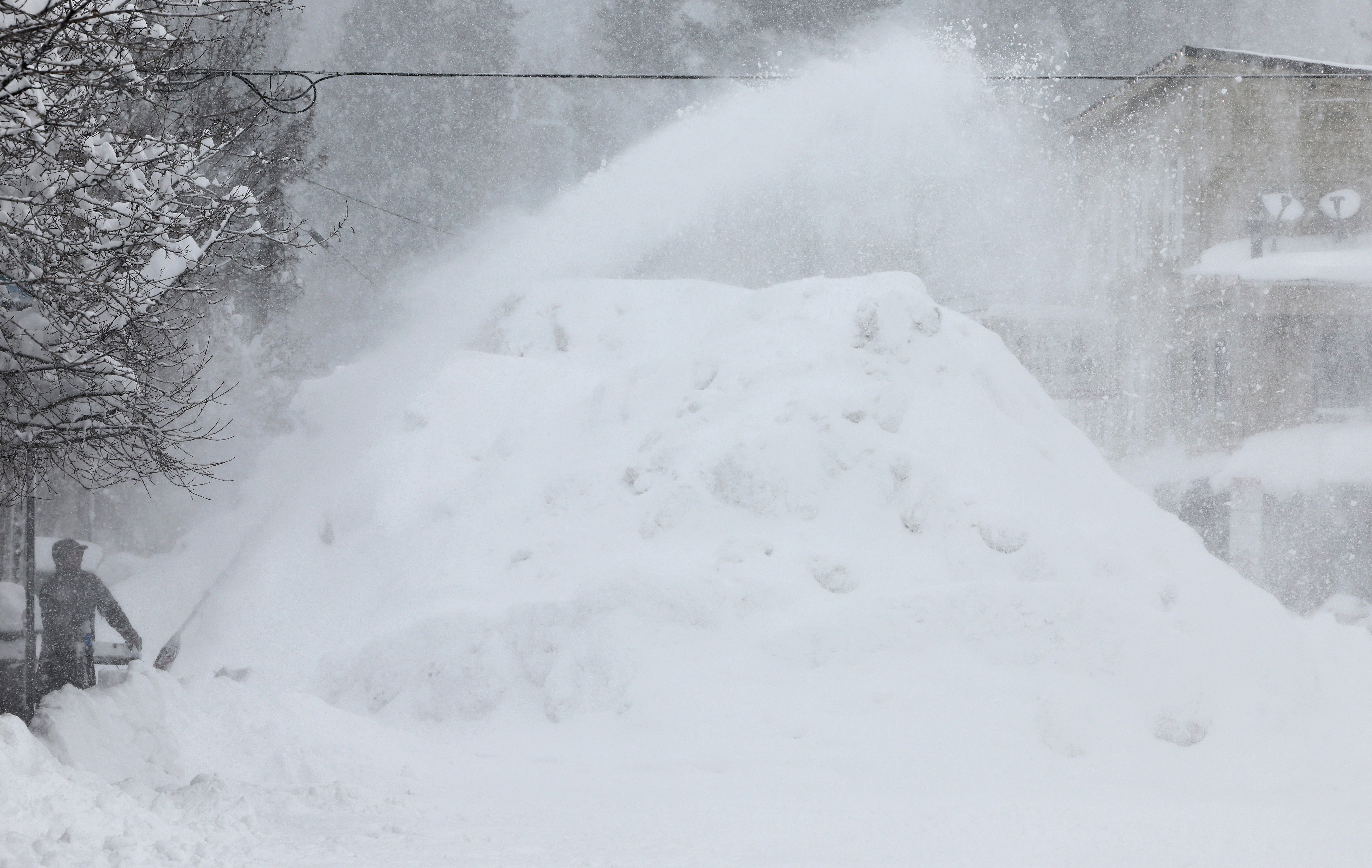 A person uses a snowblower during a powerful multiple day winter storm in the Sierra Nevada mountains on March 03, 2024 in Truckee, California