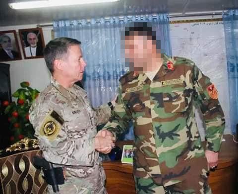 An Afghan colonel, pictured here shaking hands with four-star US general Austin Scott Miller, was threatened with deportation to Rwanda after he came to the UK via small boat