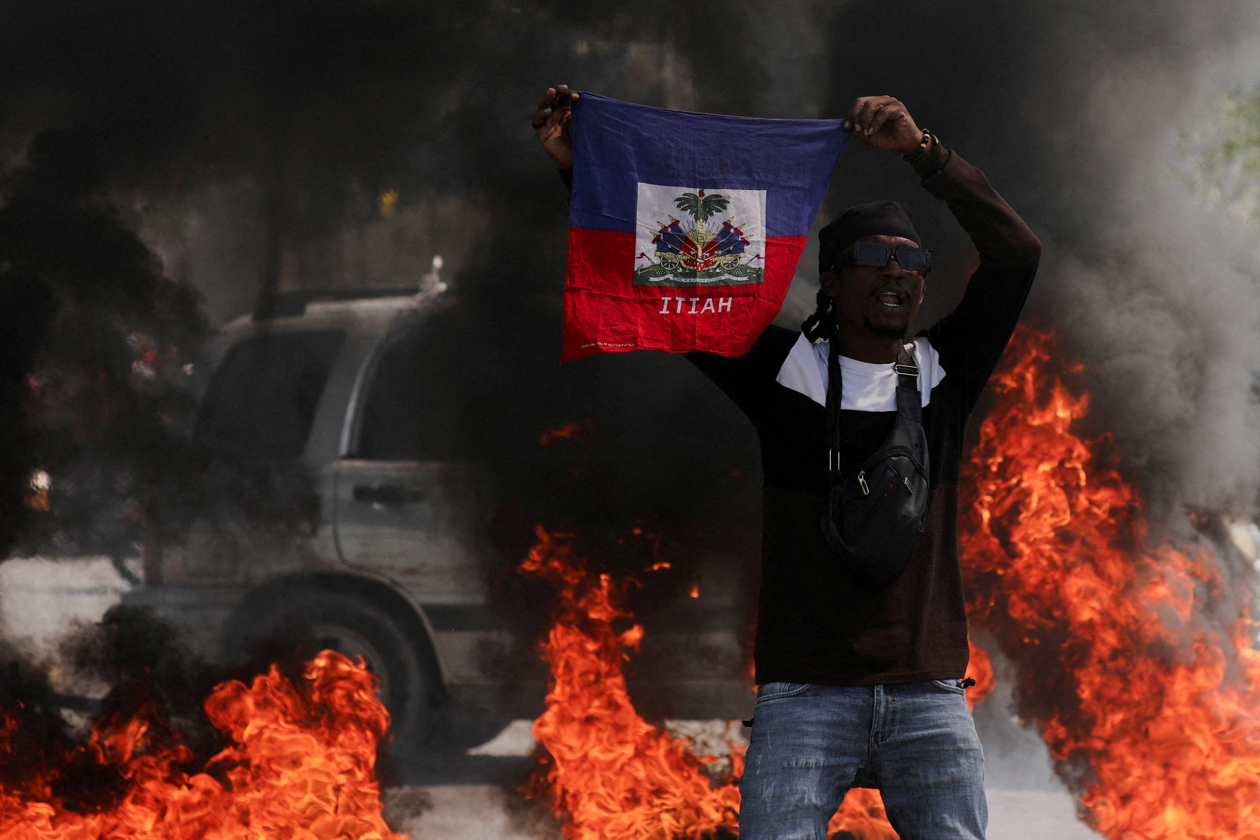 A demonstrator holds up a Haitian flag during a protest against Prime Minister Ariel Henry’s government