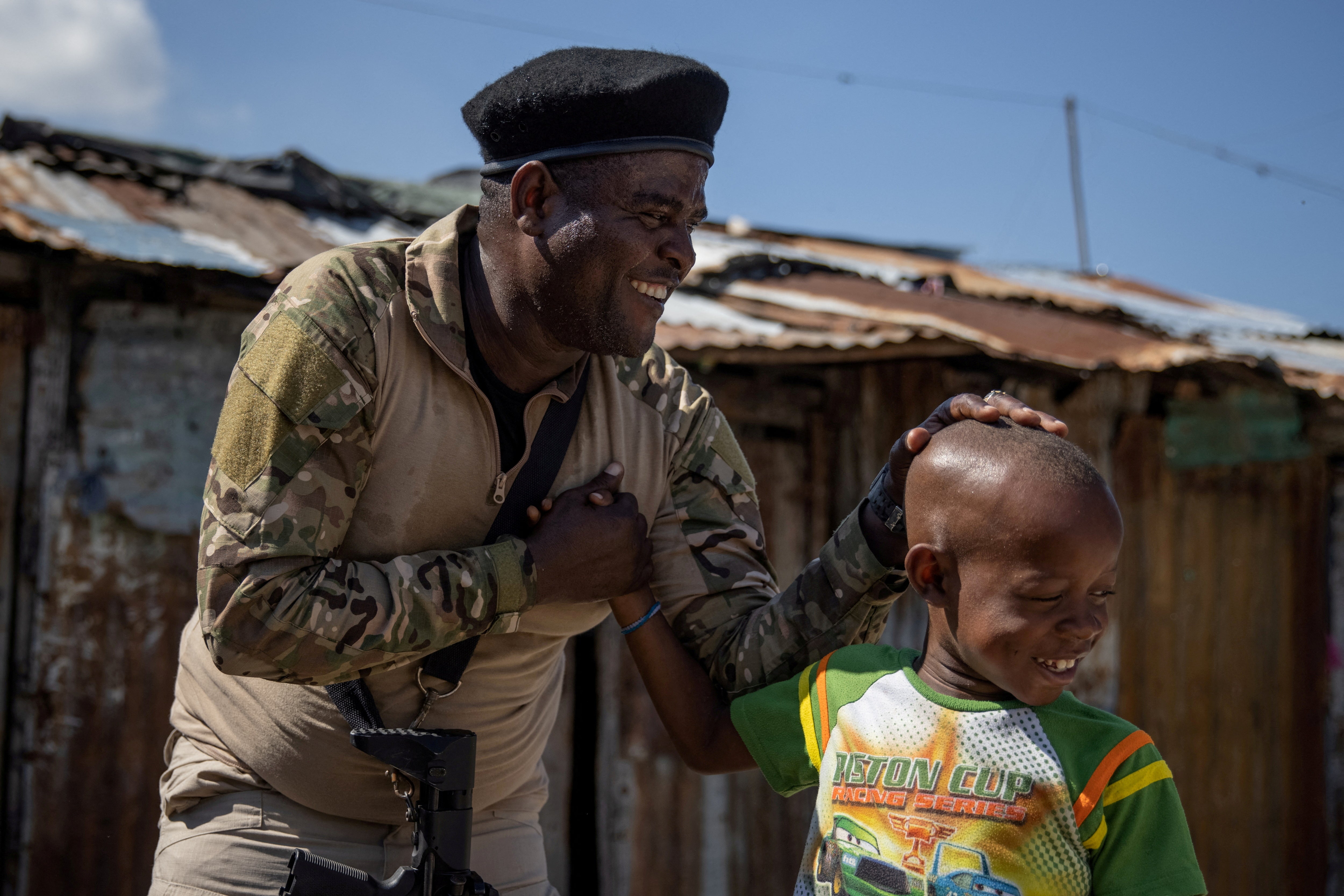 Former police officer Jimmy 'Barbecue’ Cherizier, leader of the ‘G9’ coalition, greets a boy while giving a press tour of the La Saline shanty area of Port-au-Prince,