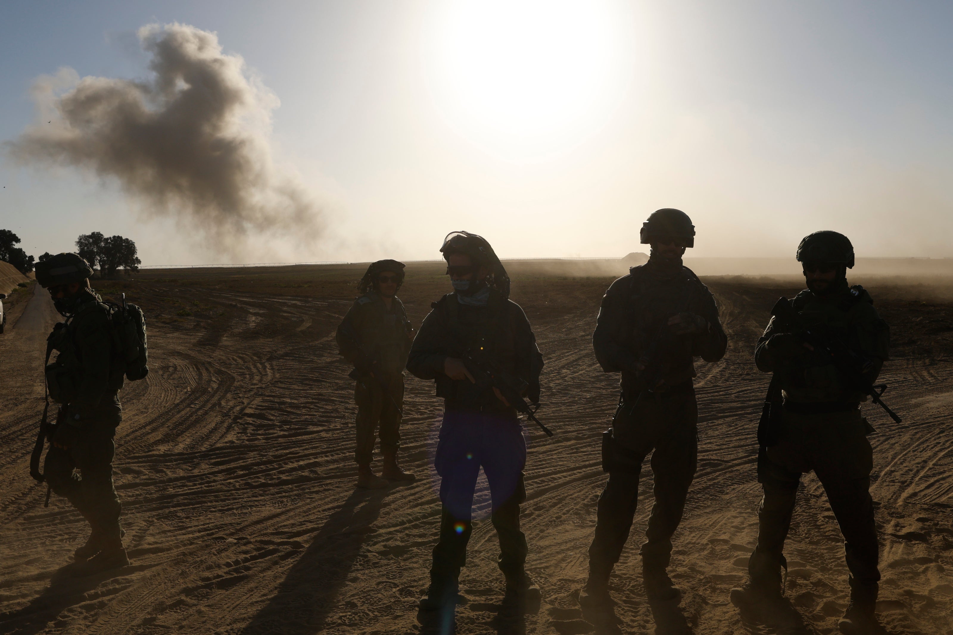 Israeli soldiers patrol as smoke is seen over Gaza after an Israeli bombardment on 4 March 2024 in southern Israel