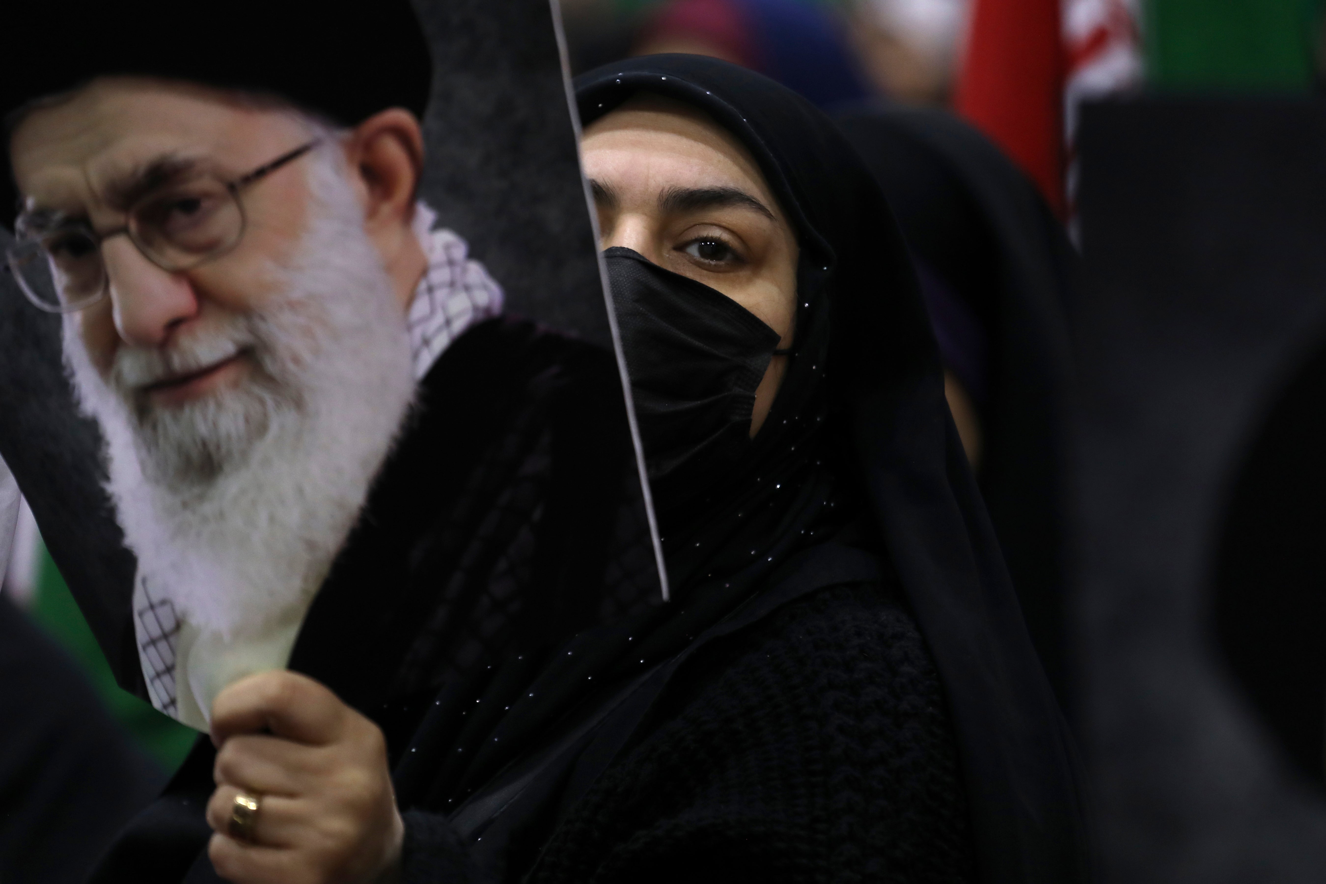 An Iranian woman holds a poster of the supreme leader Ayatollah Ali Khamenei during an election campaign
