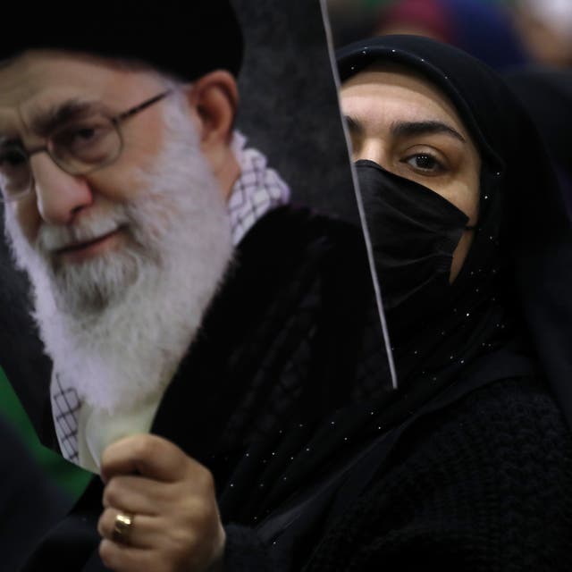 <p>An Iranian woman holds a poster of the supreme leader Ayatollah Ali Khamenei during an election campaign</p>