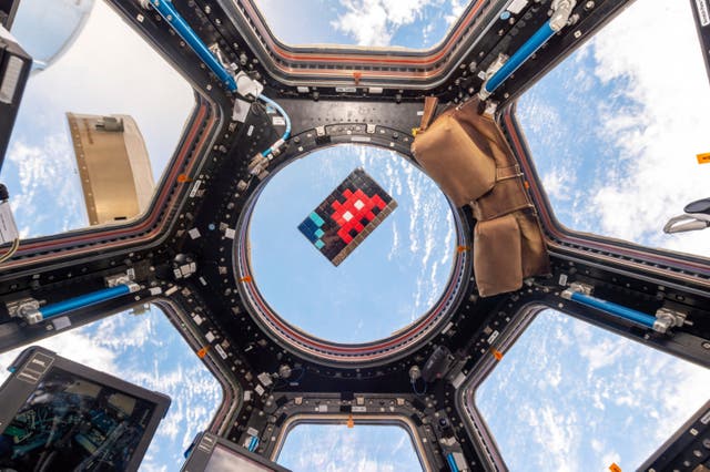 <p>A mosaic by French artist Invader floats in the International Space Station in 2015</p>