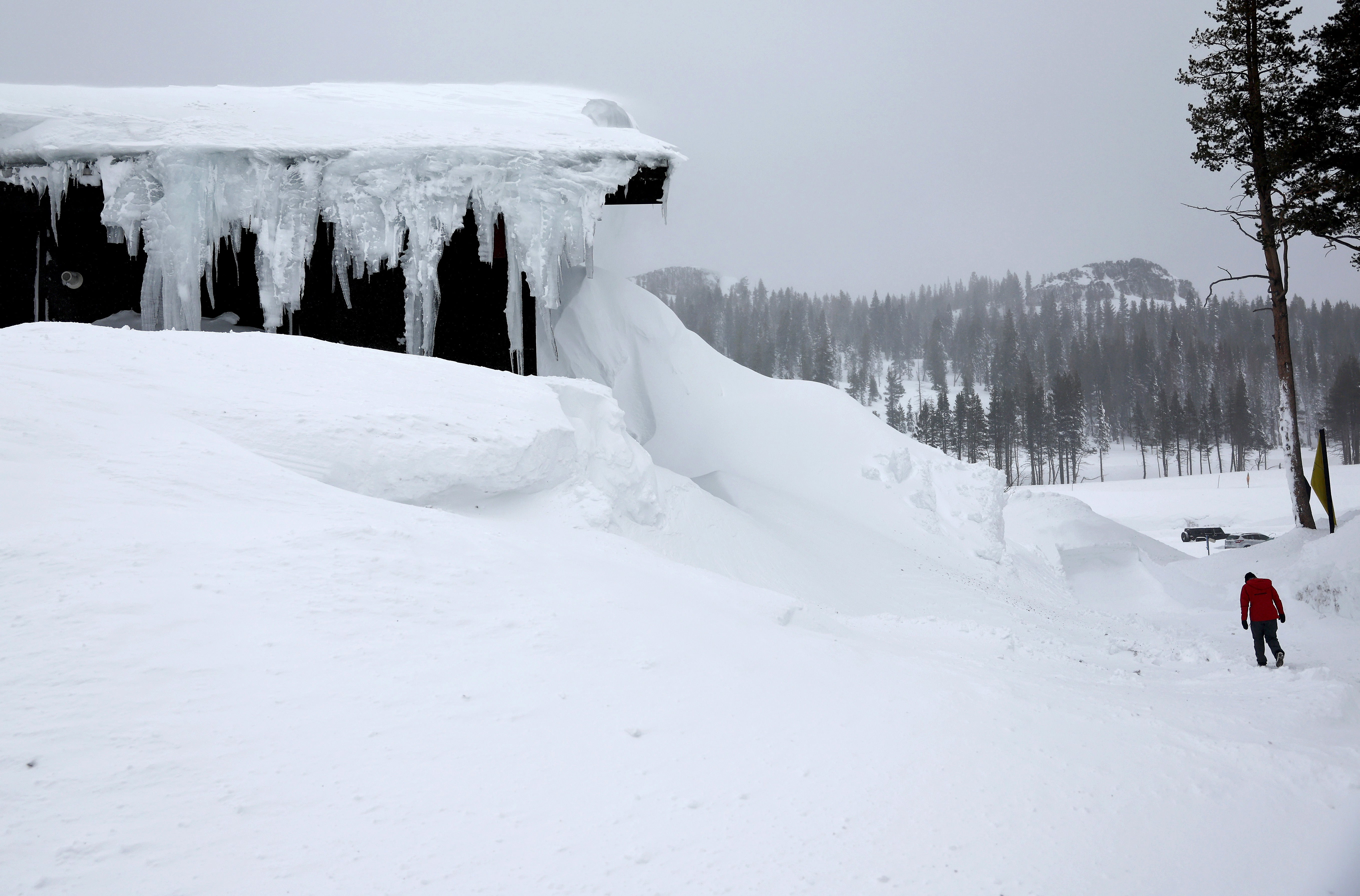 : A person walks at Boreal Mountain Resort, currently shuttered due to the snowstorm, following a massive snowstorm in the Sierra Nevada mountains on March 04, 2024 at Soda Springs, California