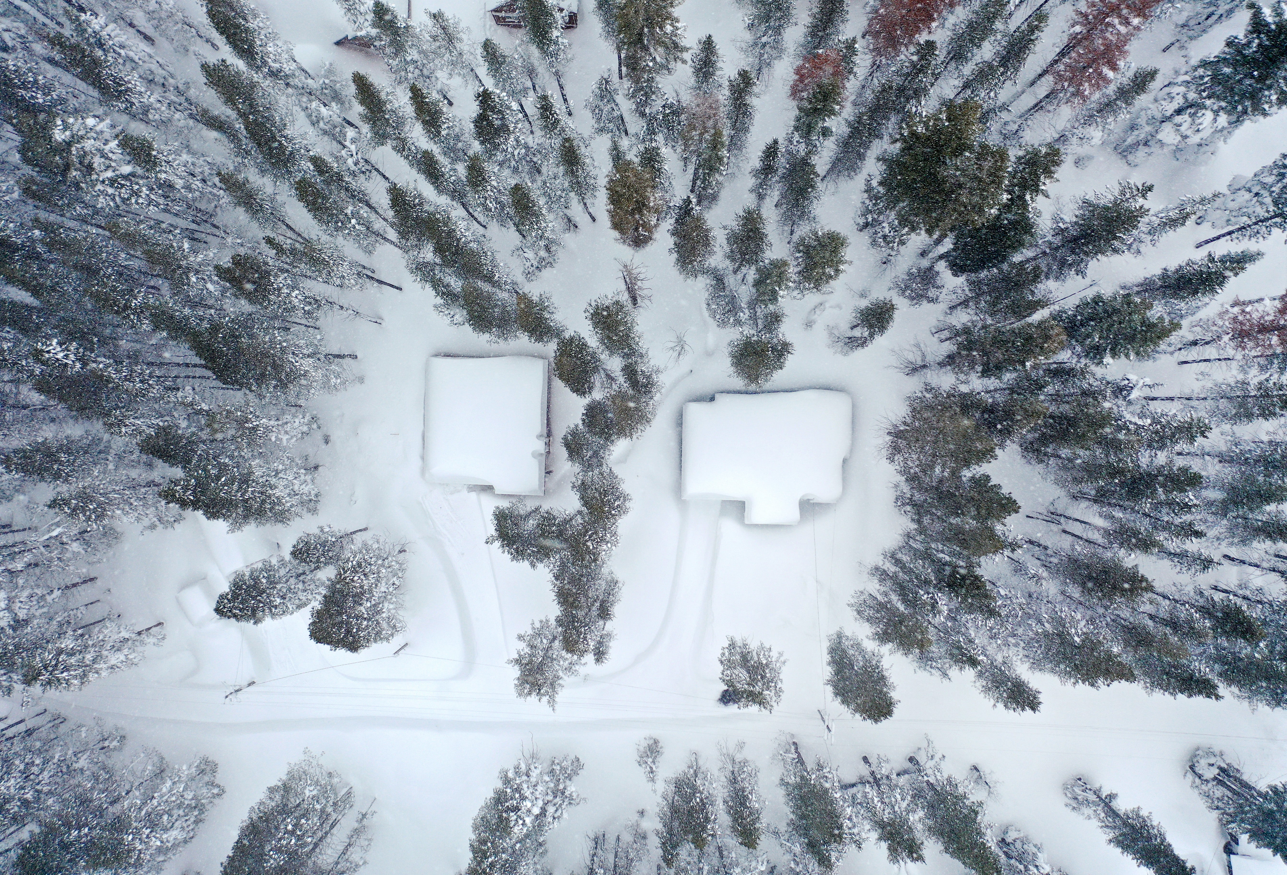 In an aerial view, homes are covered in snow following a massive snowstorm in the Sierra Nevada mountains on March 04, 2024 near Soda Springs