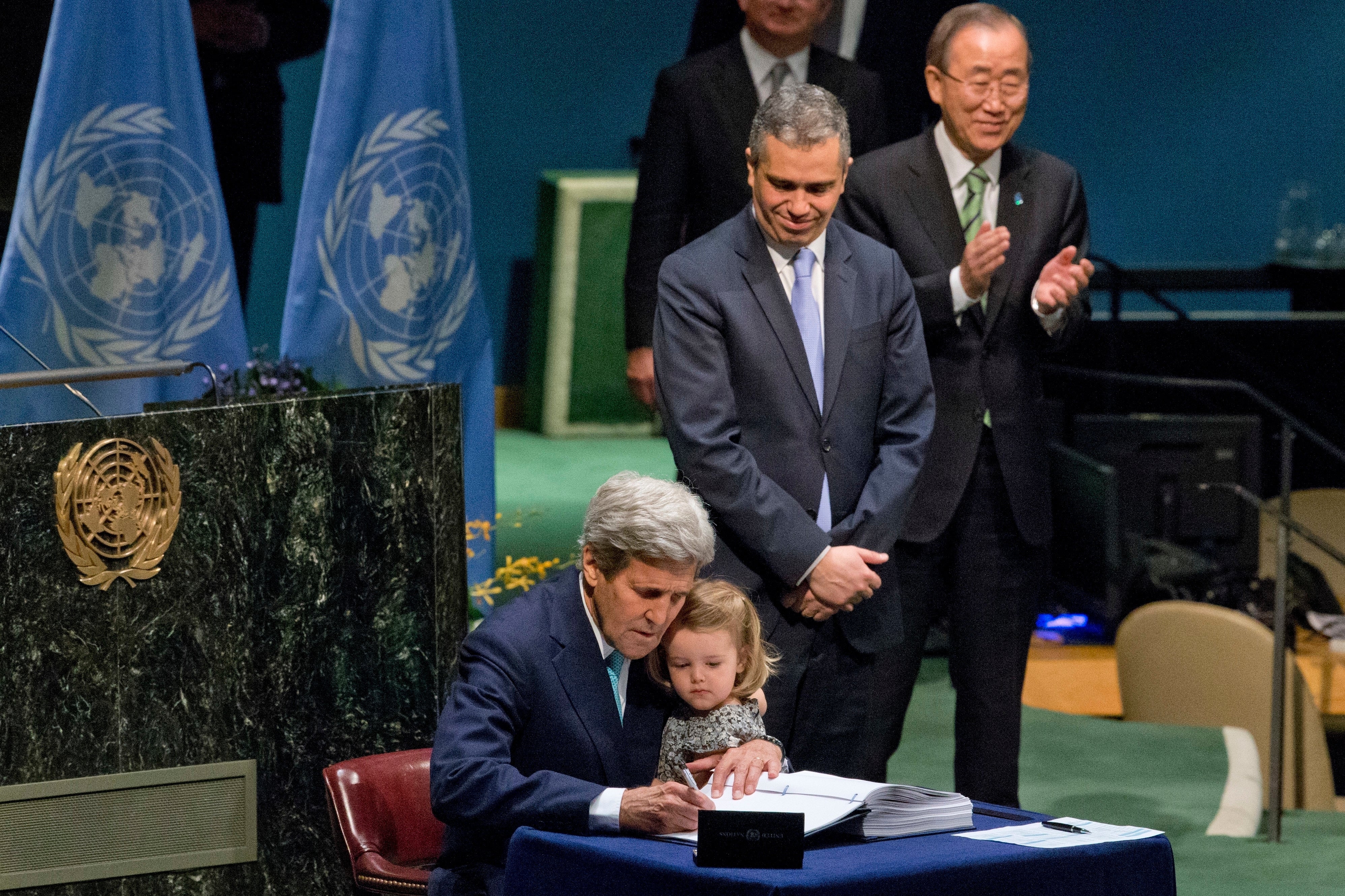 Secretary of State John Kerry holds his granddaughter as he signs the Paris Agreement on climate change, April 22, 2016 at U.N. headquarters