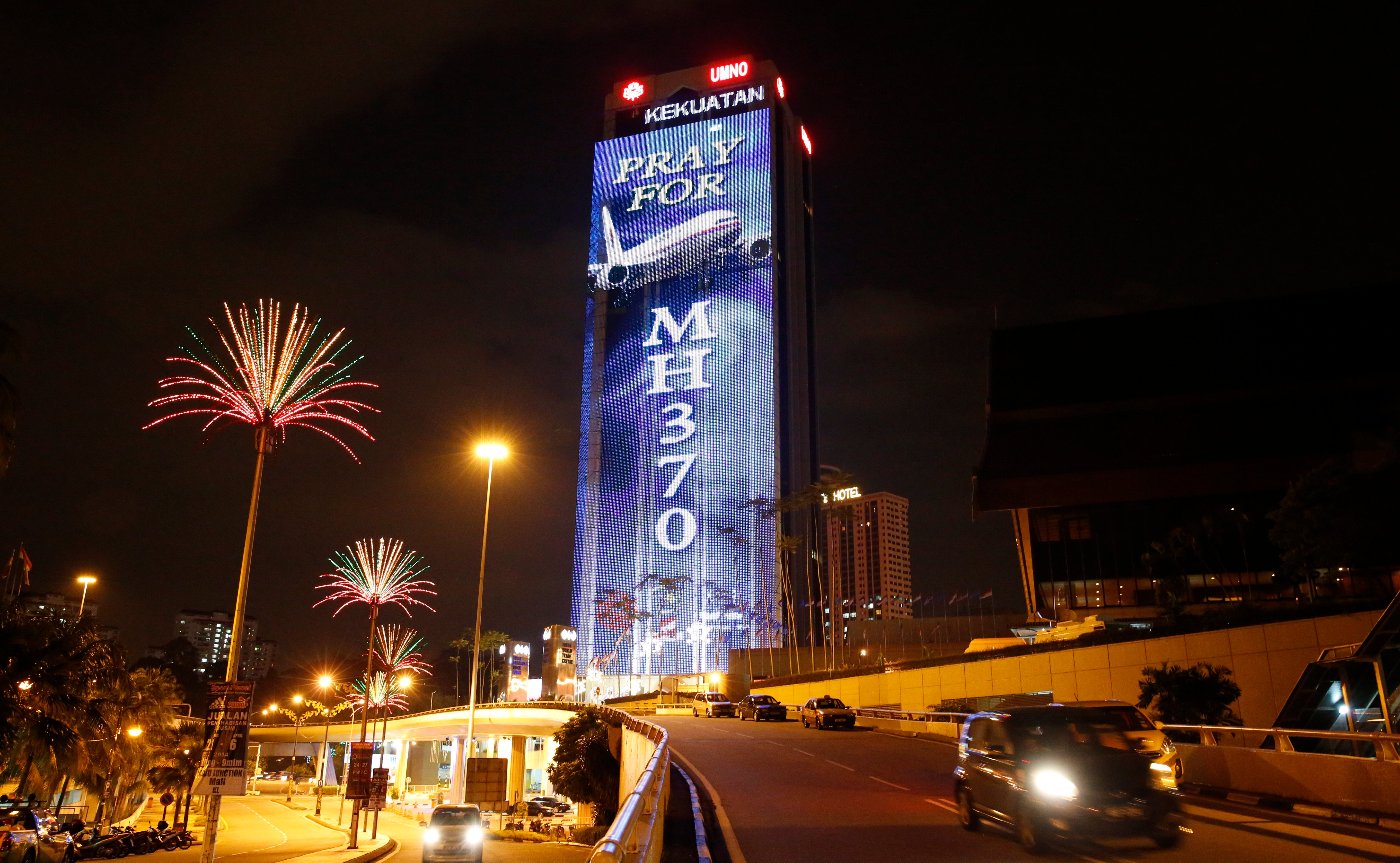 An office building is illuminated with lights displaying "Pray for MH370" in Kuala Lumpur, Malaysia in 2014