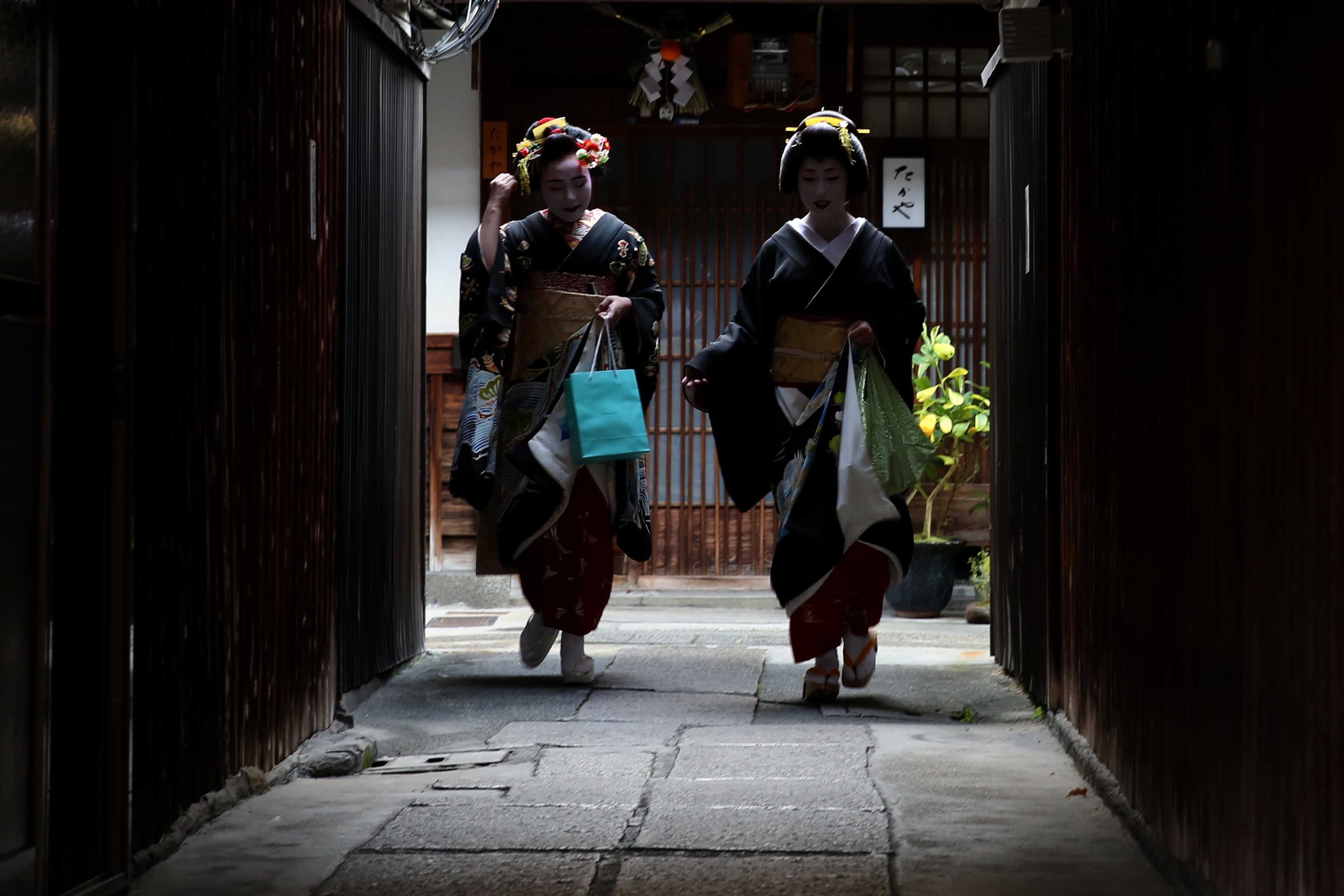 <p>Japanese traditional female dancers, maikos, and performers, geikos leave after attending the new year’s ceremony at the Gion Kobu Kaburenjo Theater in Kyoto</p>