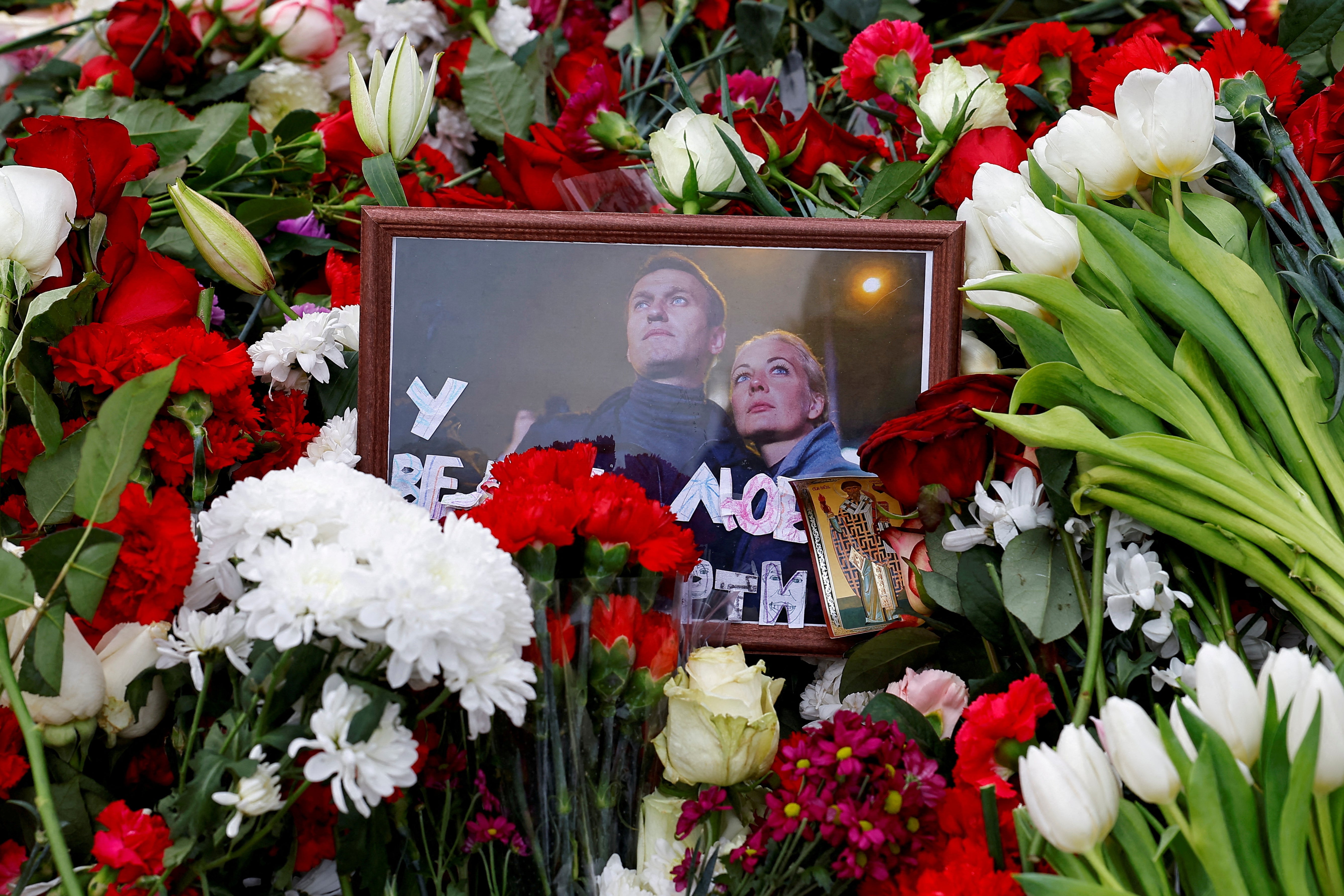 A photograph of the Navalnys is placed amid flowers on the Moscow grave of the Russian opposition leader