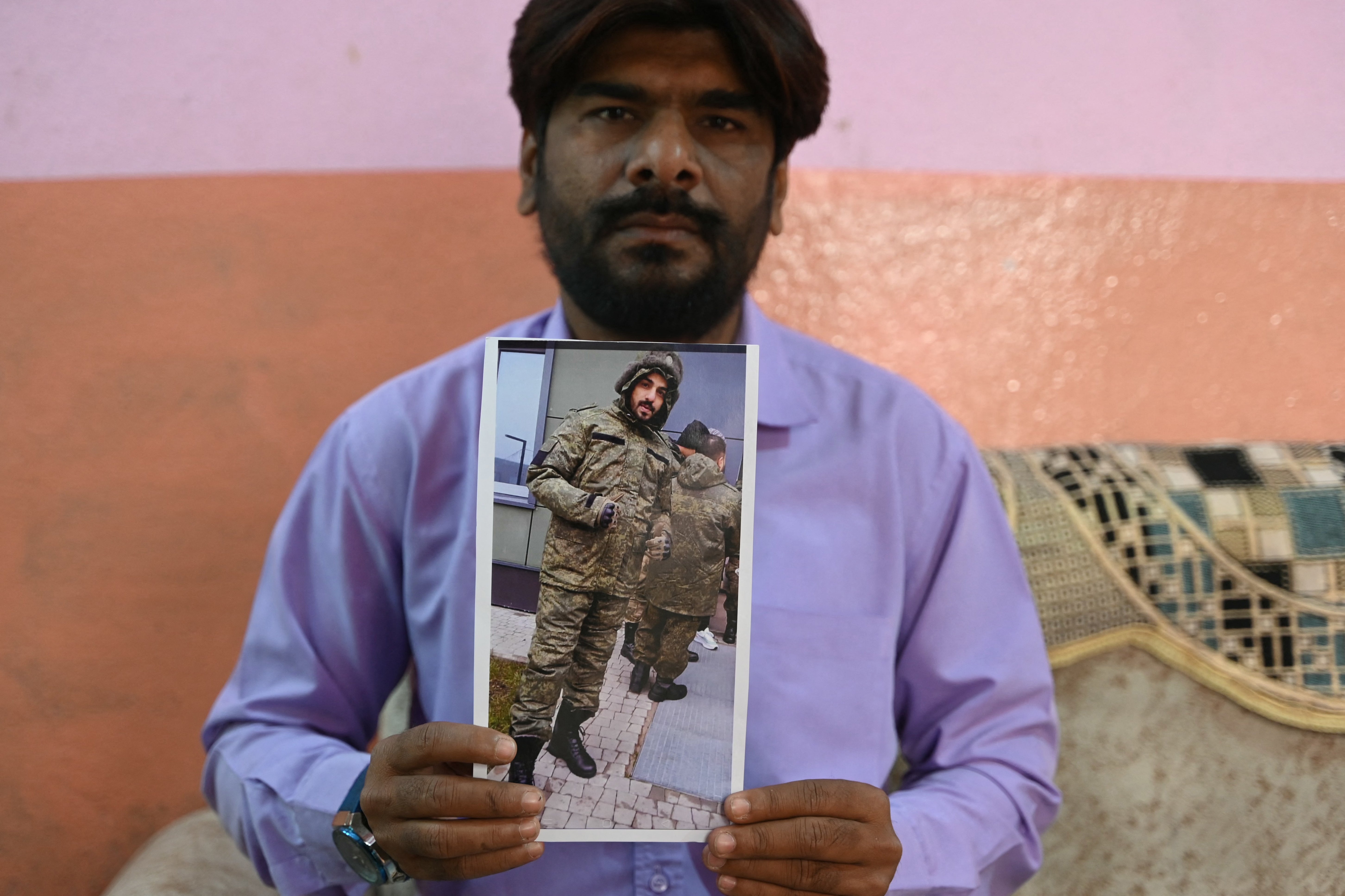 This photo taken on February 22, 2024 shows a picture printout of Indian national Mohammed Asfan, seen wearing Russian military fatigues, who last called family from the southern Russian city before being deployed amid the conflict in Ukraine