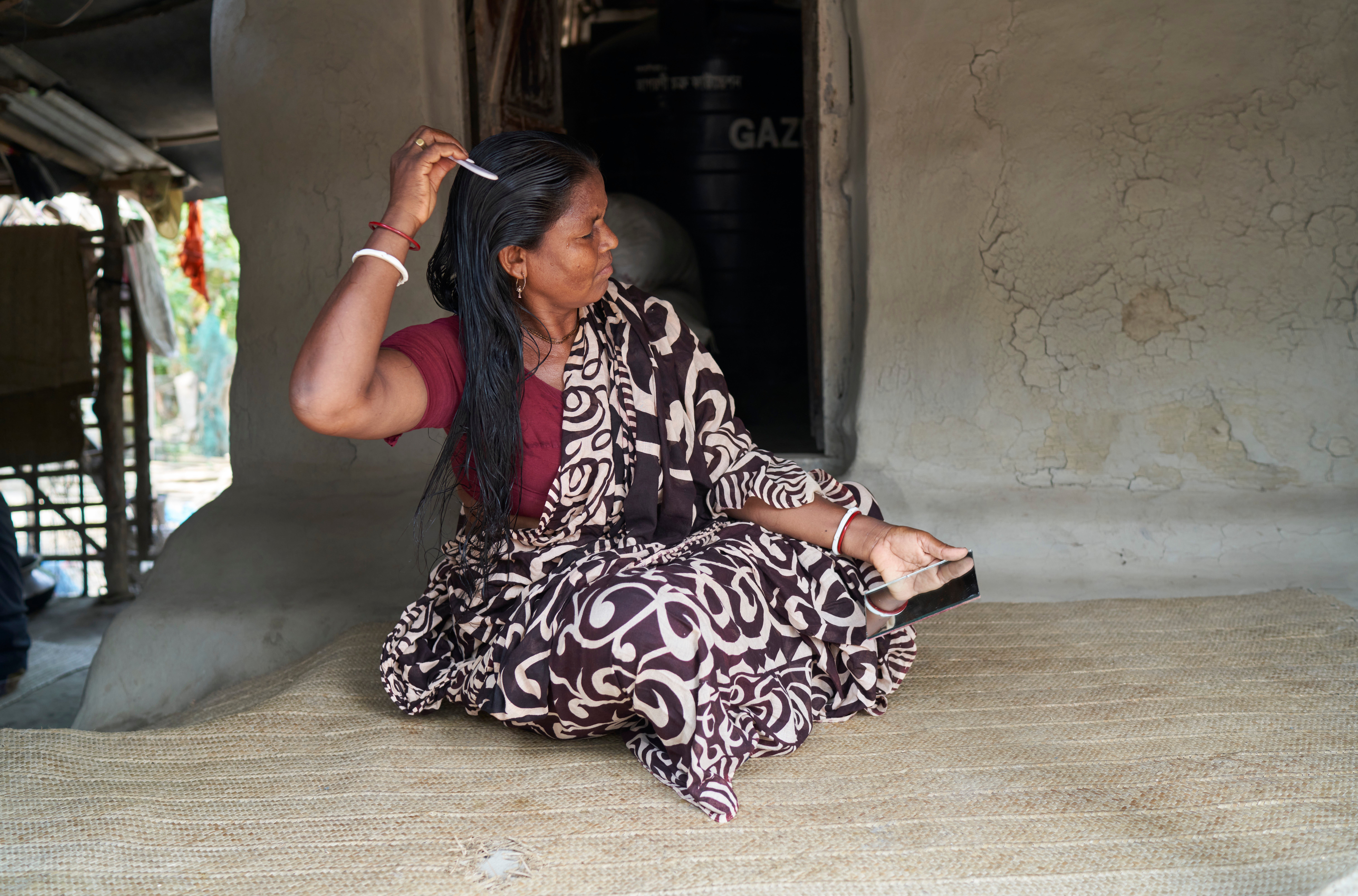 Shyamoli Munda brushing her hair, Bhetkali, Satkhira, Bangladesh