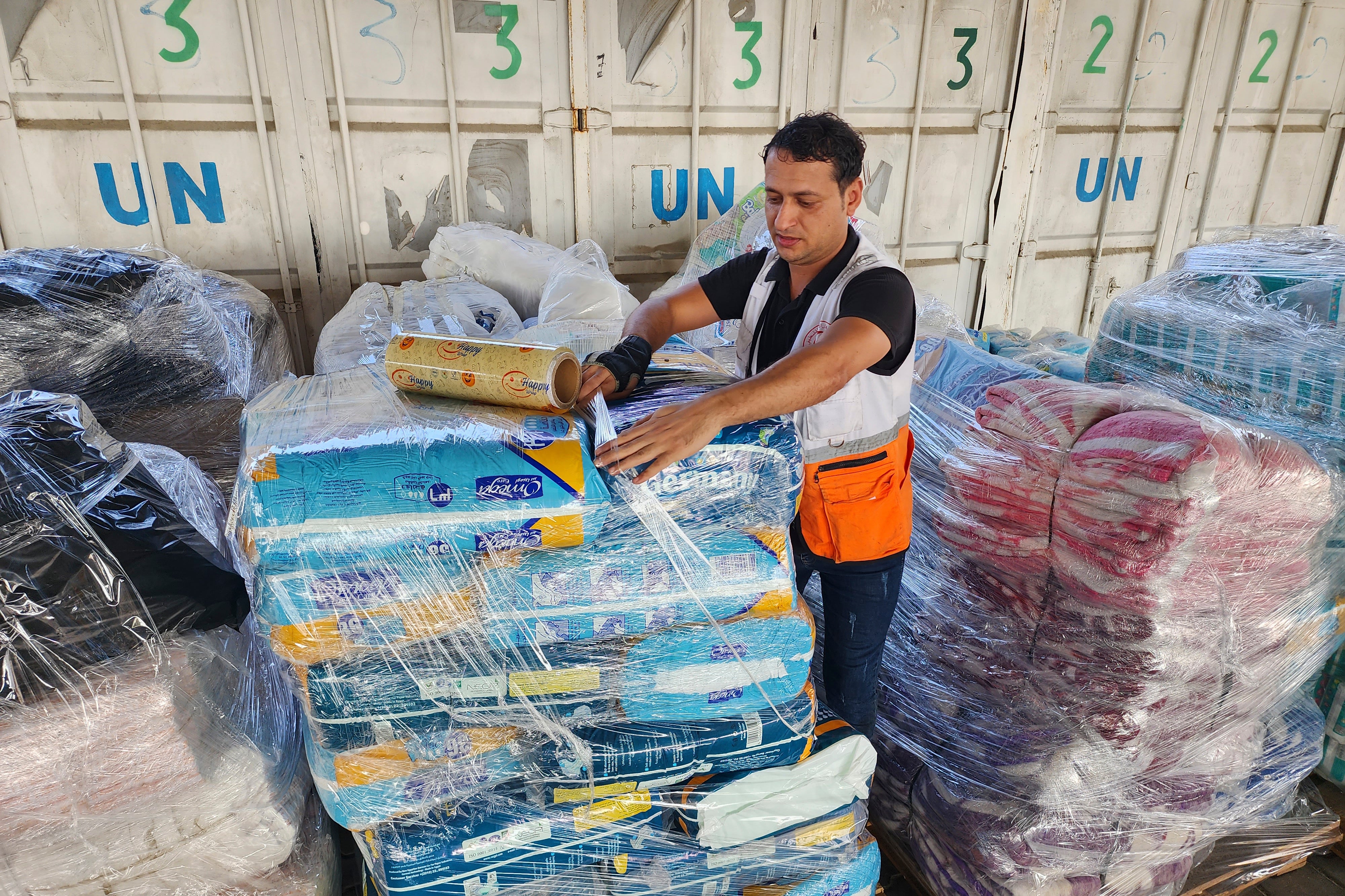 An UNRWA worker prepares to distribute aid
