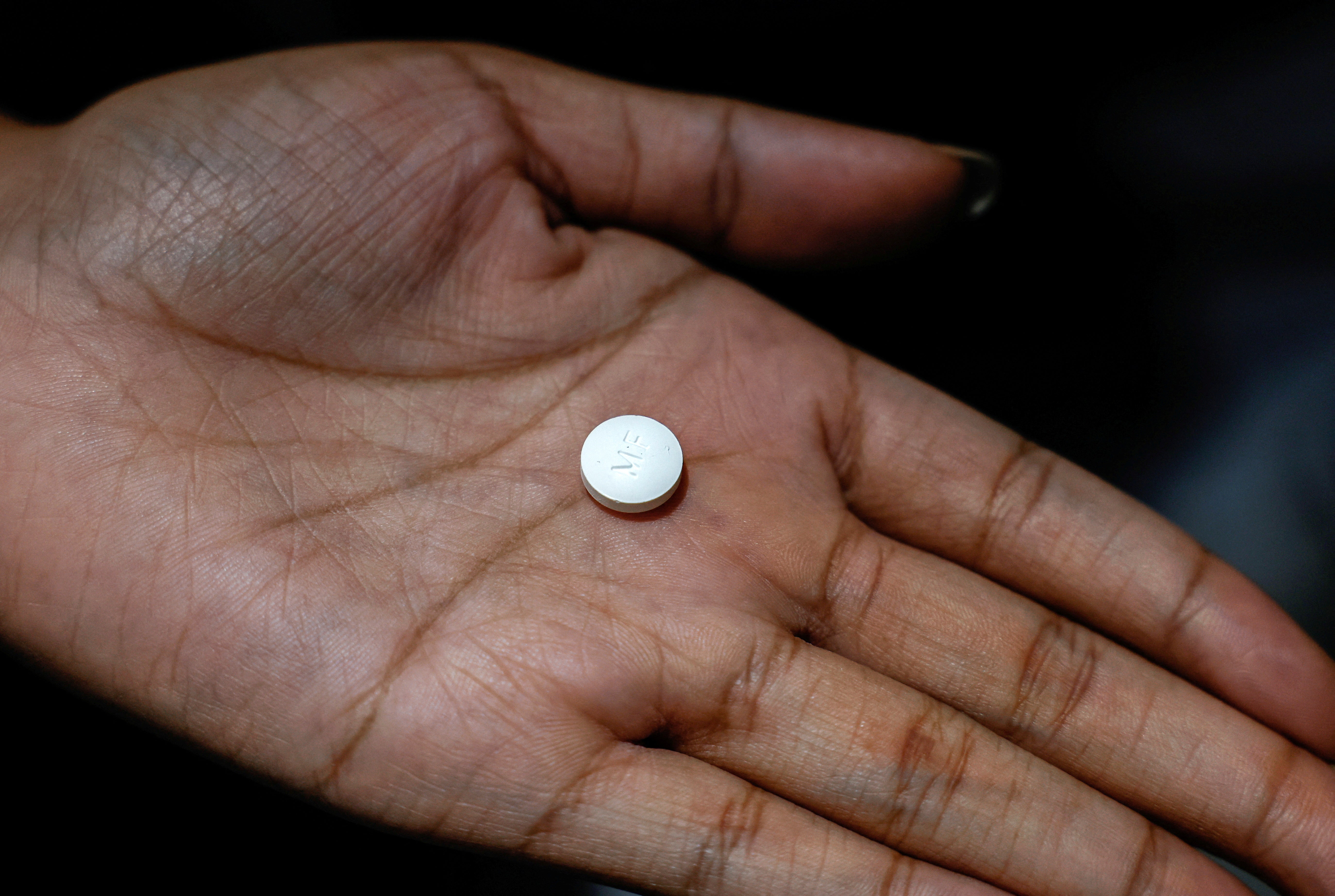 A patient holds a mifepristone pill, one of two drugs in a two-drug regimen for a medication abortion, the most common form of abortion care in the US