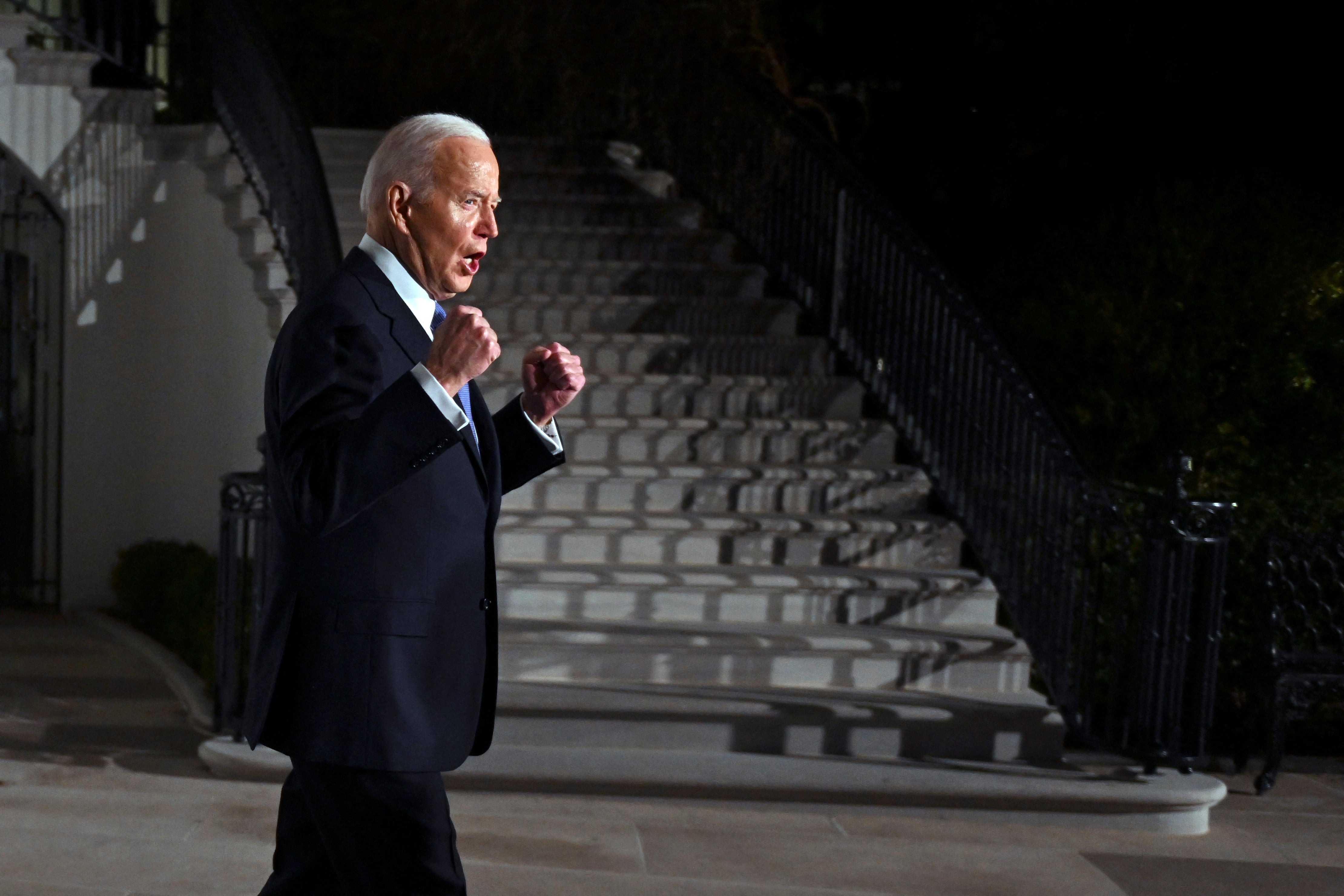 Biden gestures as he leaves the White House