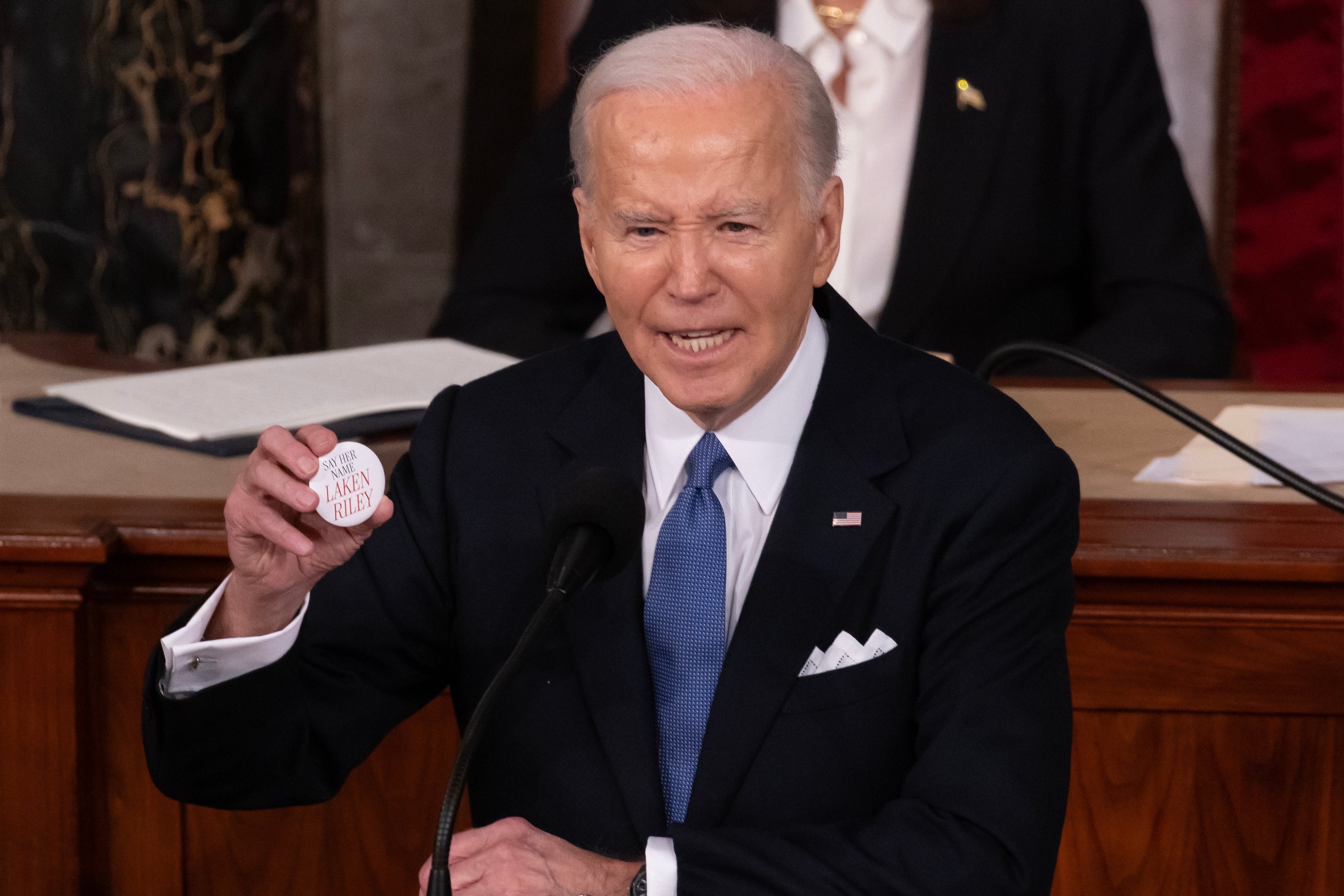 President Joe Biden holds up a pin referring to murdered Georgia student Laken Riley while delivering his State of the Union address