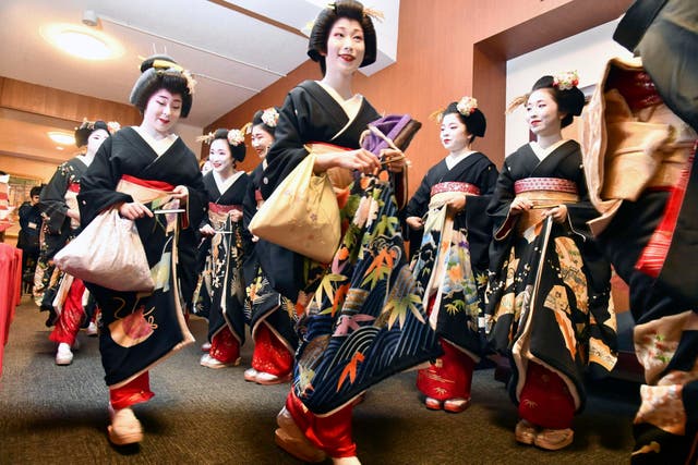<p>Kimono-clad ‘geiko’ and ‘maiko’ professional entertainers arrive for a ceremony to start this year's business in Kyoto</p>