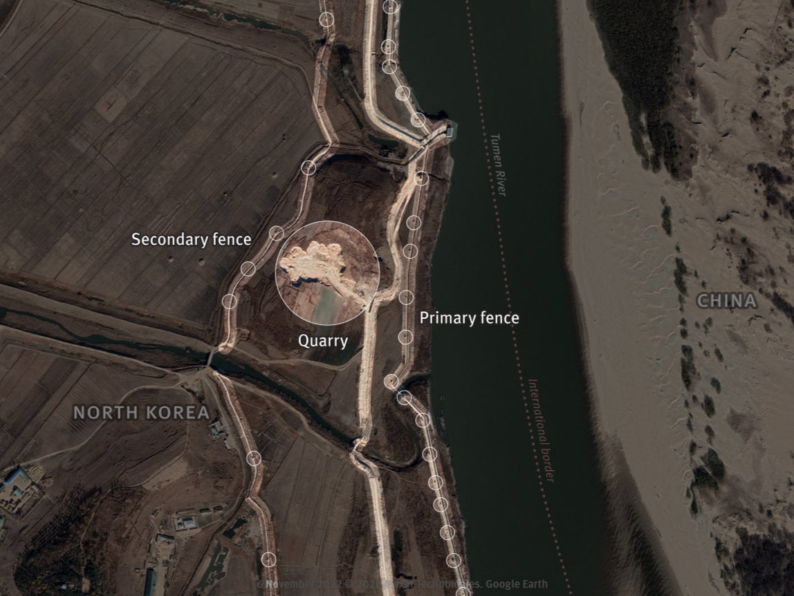In May 2019, no security is visible along the Tumen River. November 2022 – Primary and secondary fences have been built. A new primary fence and patrol roads are under construction in 2022, using materials sourced from nearby quarry that used to be agricultural fields. The first primary fence (in blue) will be dismantled once the new one is built, as shown in next close up