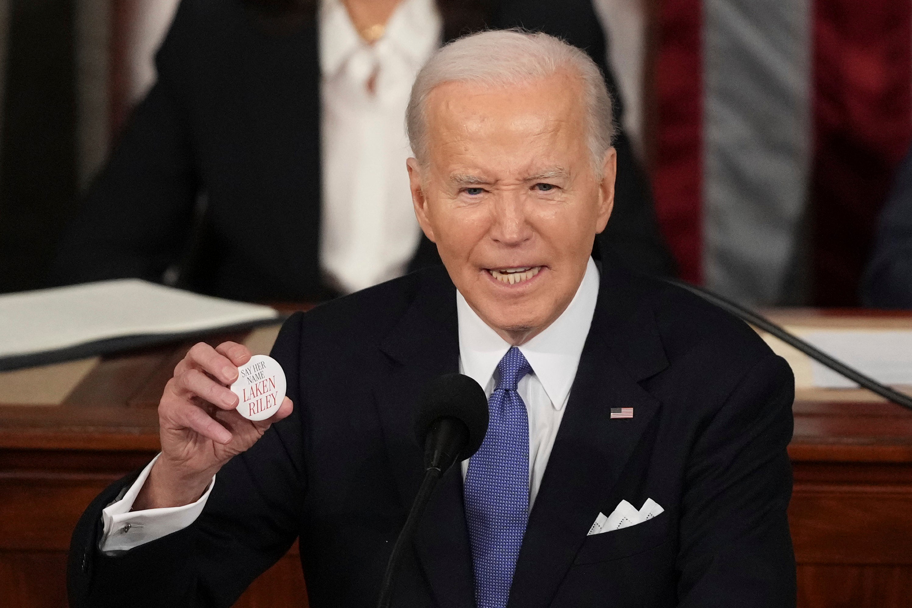 President Joe Biden holds up a pin bearing Laken Riley’s name during his State of the Union address