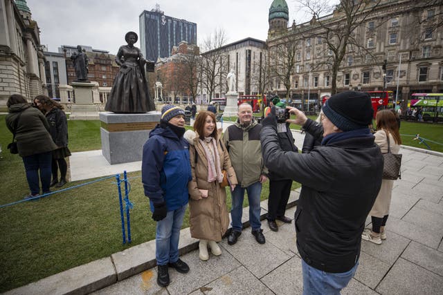 People taking a photo of Mary Ann McCracken during the unveiling of the statue with Winifred Carney (Liam McBurney/PA)