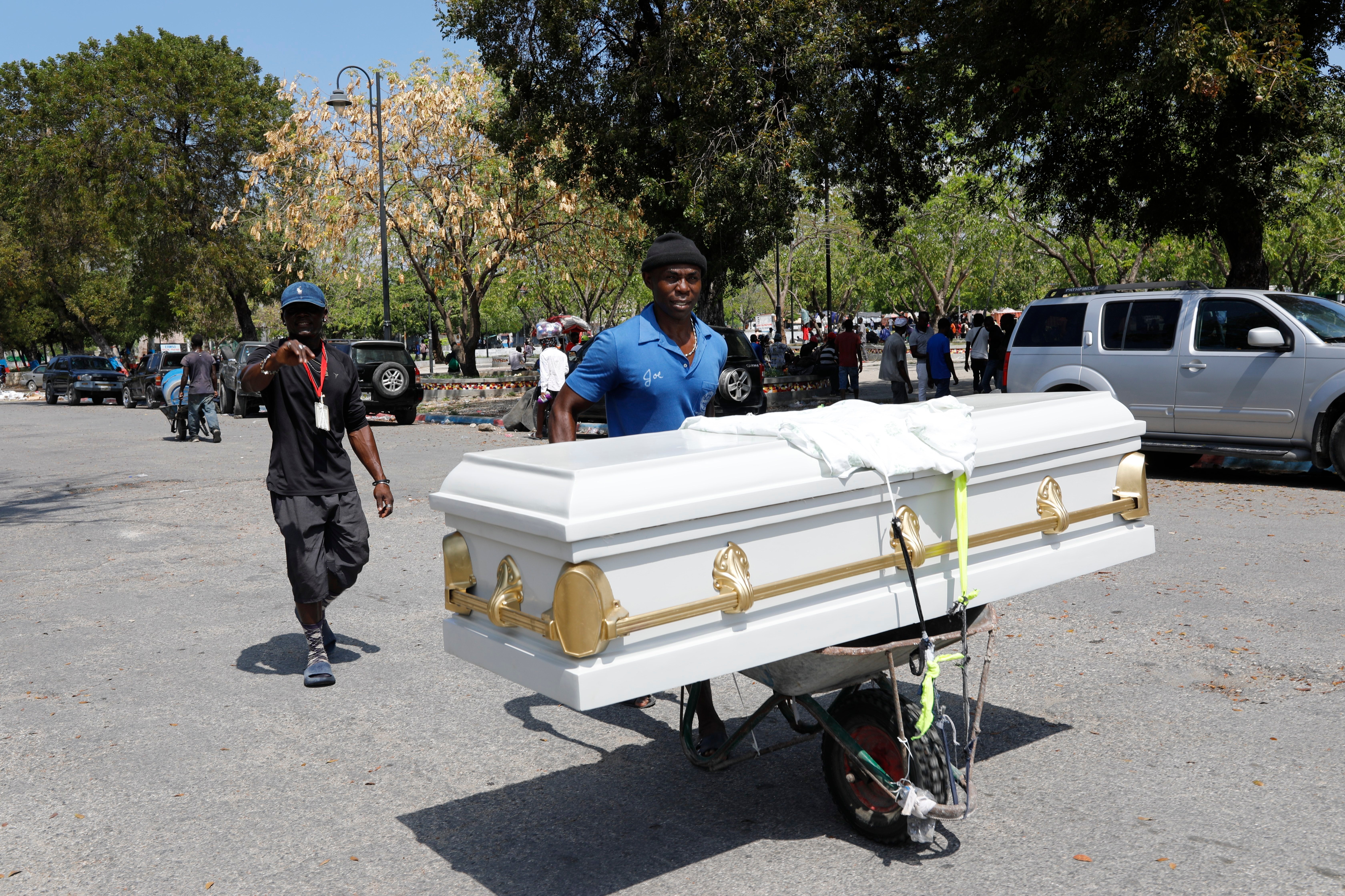 A man transports a coffin using a wheelbarrow, in Port-au-Prince, Haiti, Friday, March 8, 2024