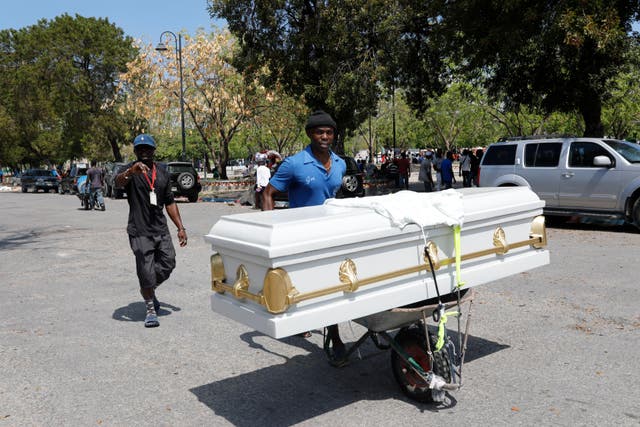 <p>A man transports a coffin using a wheelbarrow, in Port-au-Prince, Haiti, Friday, March 8, 2024</p>