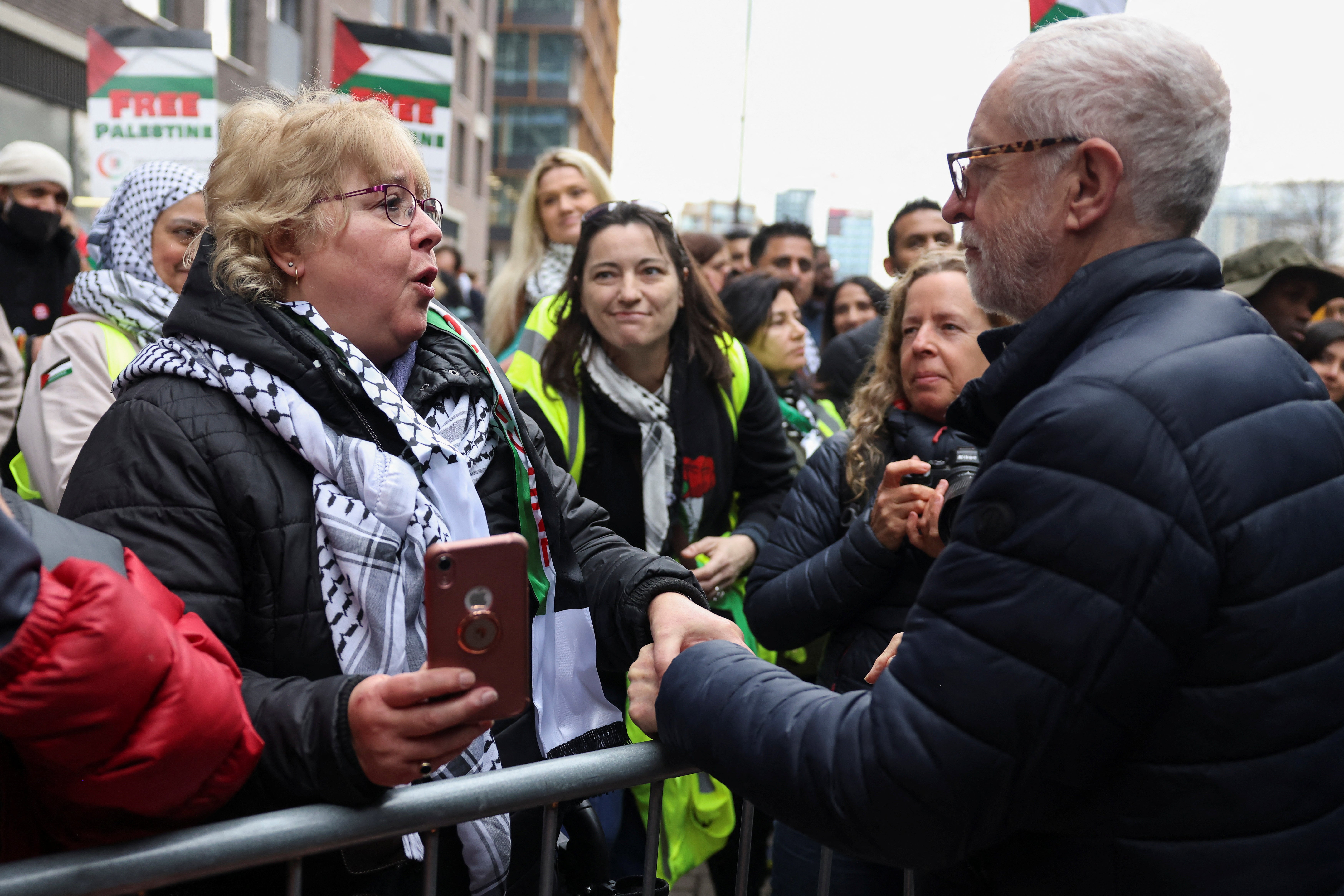 Former Labour leader Jeremy Corbyn greets a demonstrator, as they attend a pro-Palestinian protest