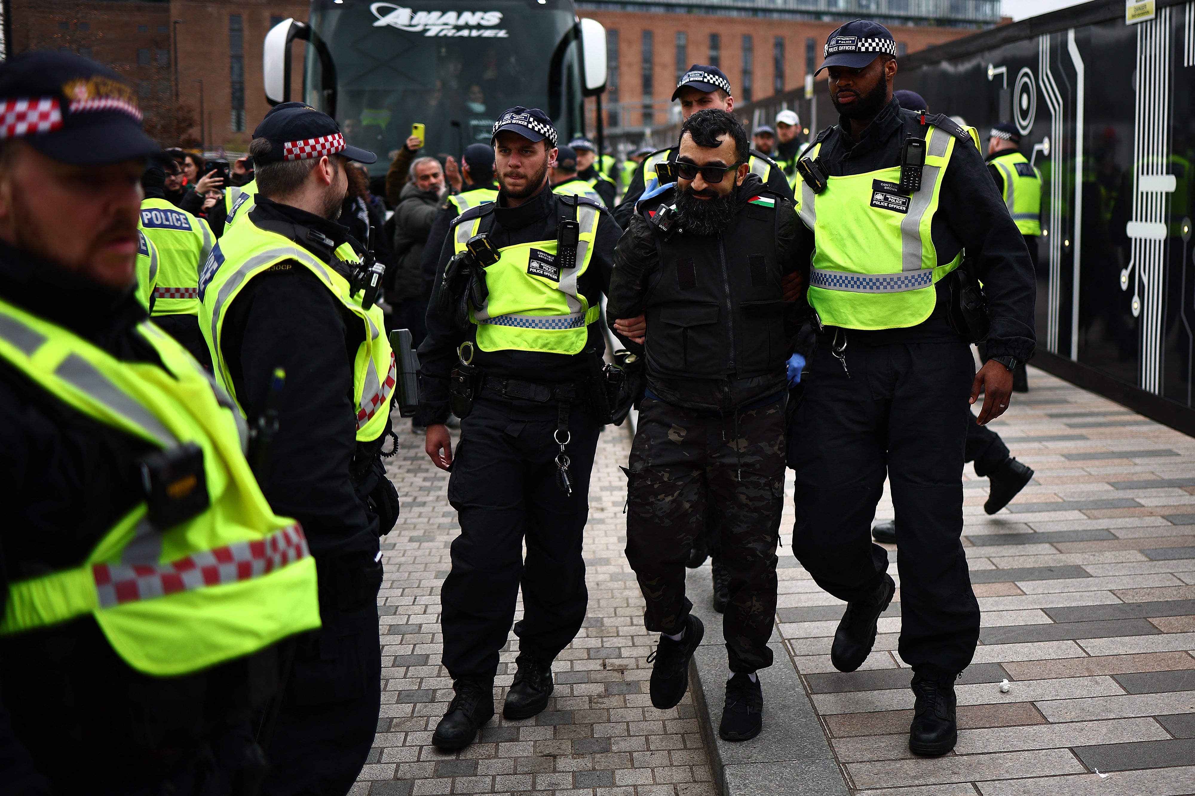 Police officers escort an arrested protester following a march through London