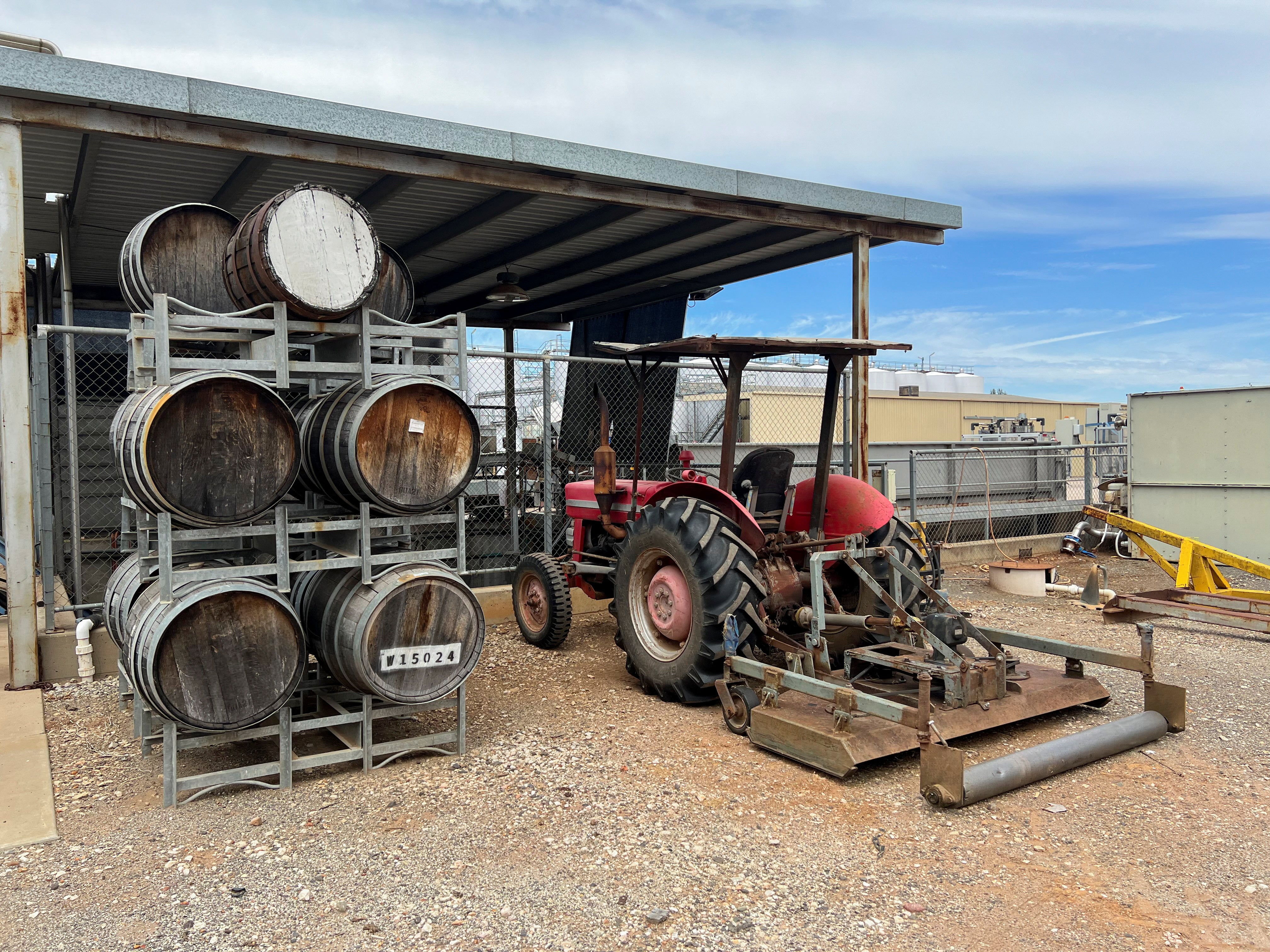<p>Barrels are stacked next to a tractor parked in the yard of Calabria Wines winery in the town of Griffith in southeast Australia </p>
