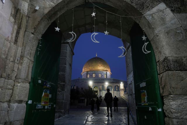 <p>Muslims walk next to the Dome of Rock Mosque at the Al-Aqsa Mosque compound in Jerusalem’s Old City</p>