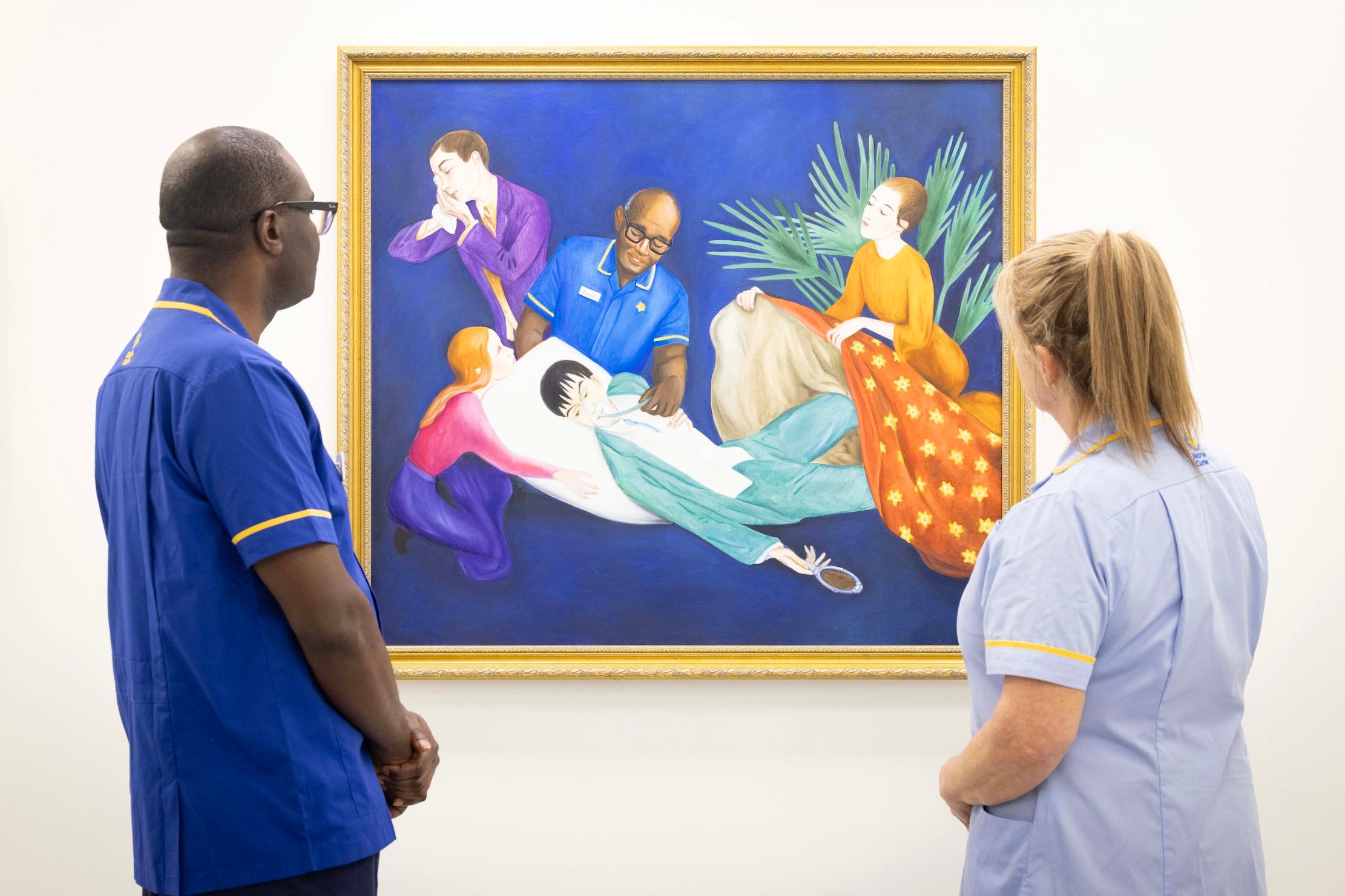 Senior Marie Curie nurse Isaac Otengo and healthcare assistant Wendy Phillips look at Lisa Buchanan’s reimagining of Nils Dardel’s The Dying Dandy (Matt Alexander/PA)