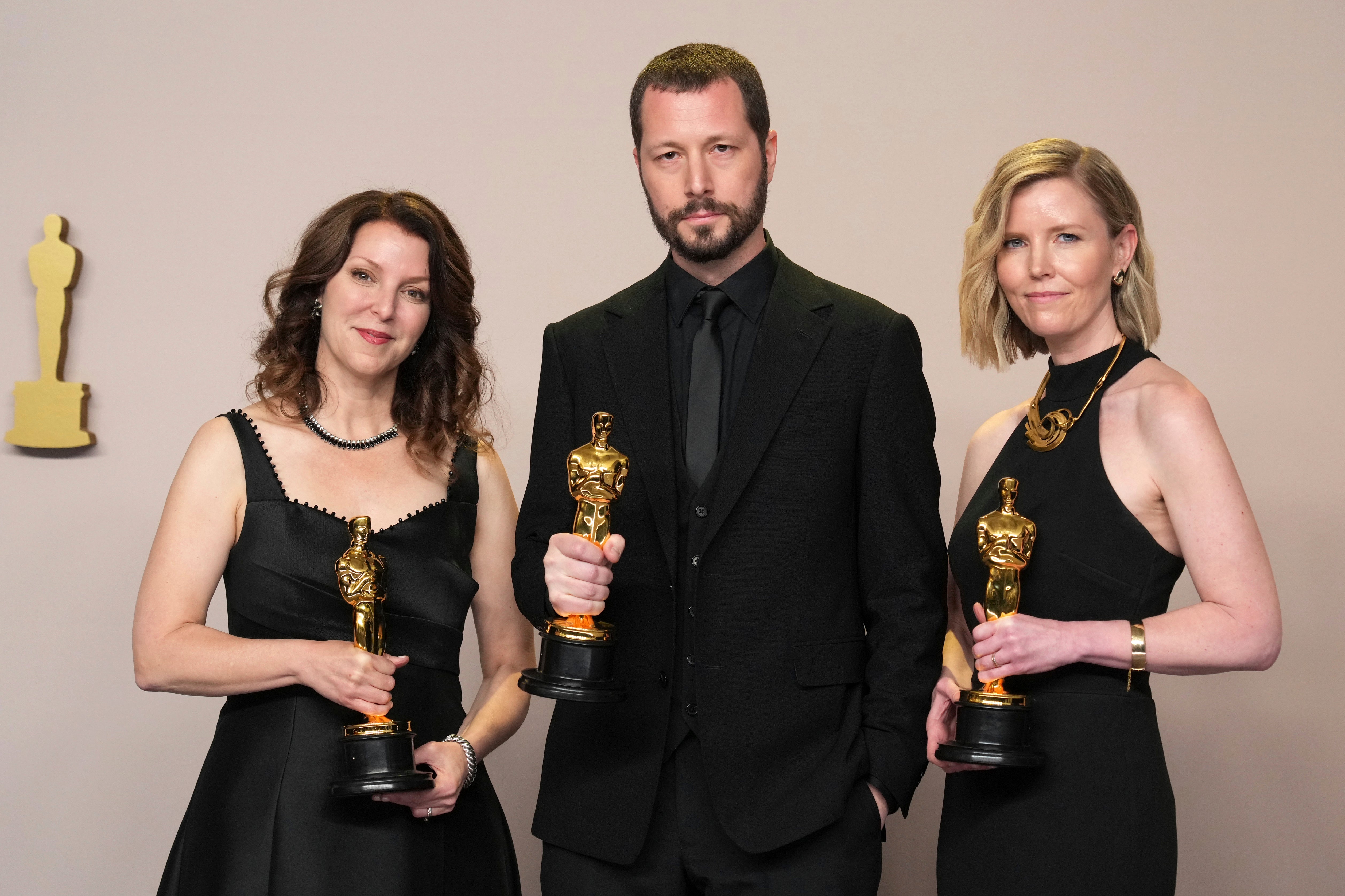 Raney Aronson-Rath, from left, Mstyslav Chernov, and Michelle Mizner pose in the press room with the award for best documentary feature film for "20 Days in Mariupol" at the Oscars