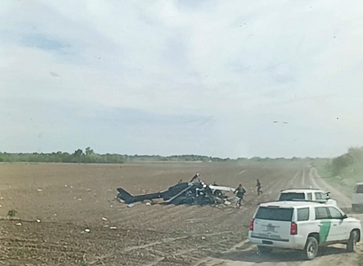 A view from inside a vehicle shows emergency services personnel responding to a helicopter crash near La Grulla, Texas, United States
