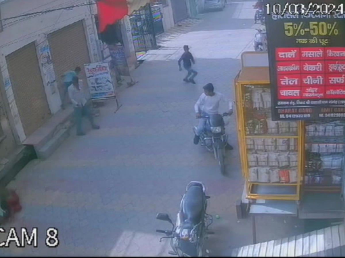 Moment wild monkey tackles boy sitting outside shop