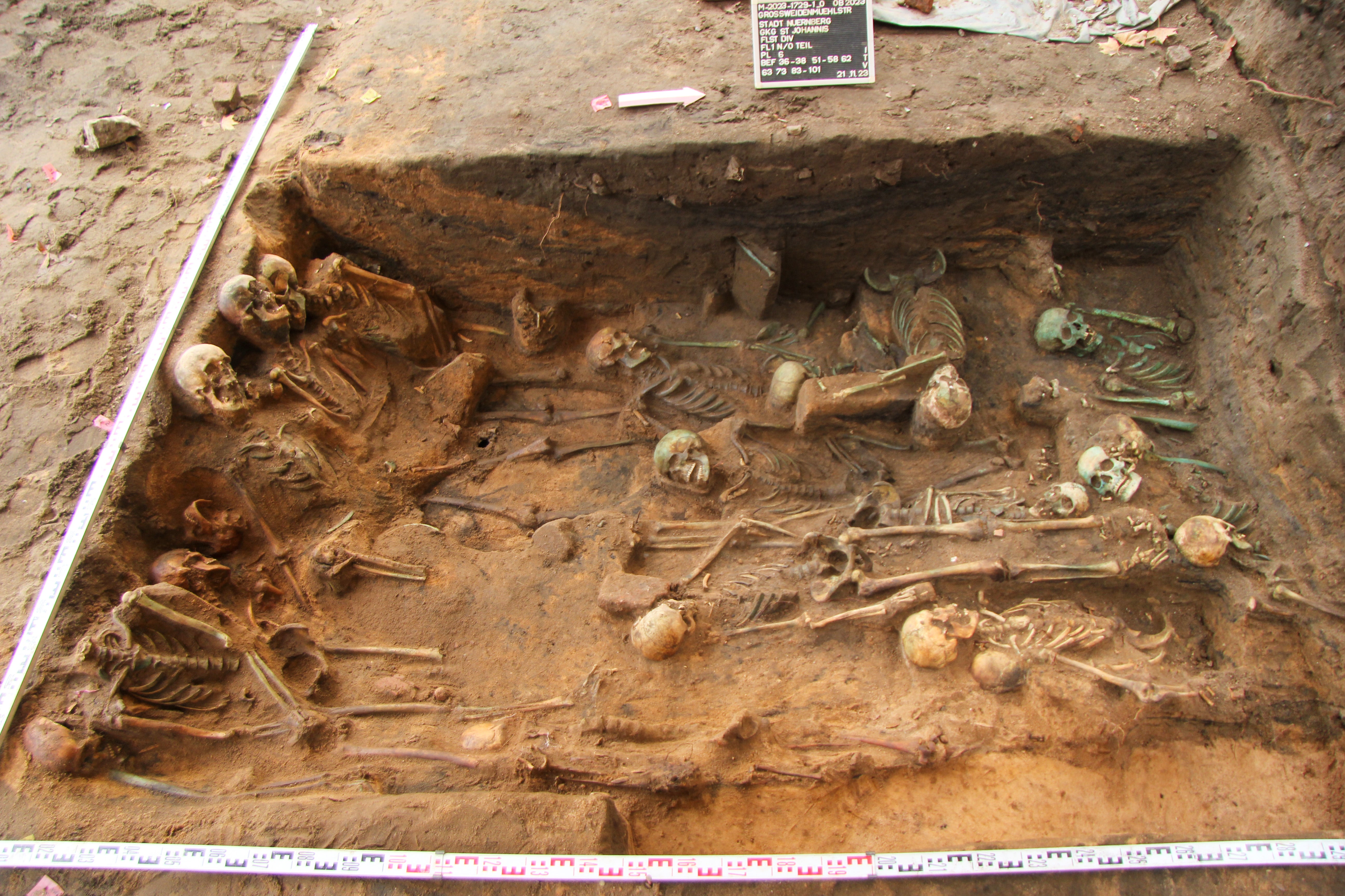 Dead buried in a sitting position (left) and people lying on their side (bottom half) with a dense filling in the centre of the pit