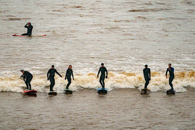 <p>Surfers ride the first a 'five-star' Severn Bore of 2024 at Newnham, Gloucestershire</p>
