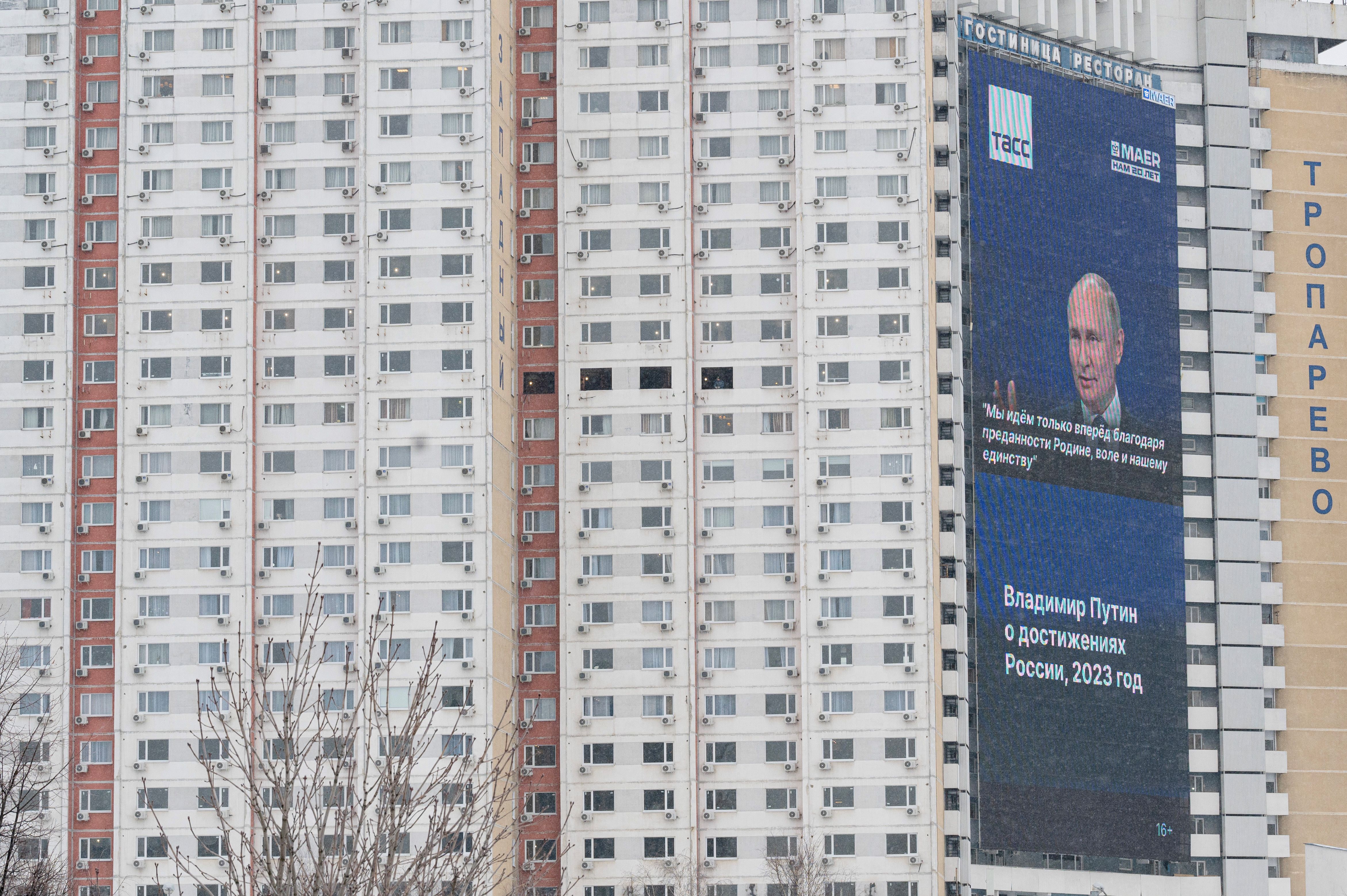 An electronic screen on the facade of a building displaying an image of Russian President Vladimir Putin and his quote on the ‘achievements' of Russia in 2023