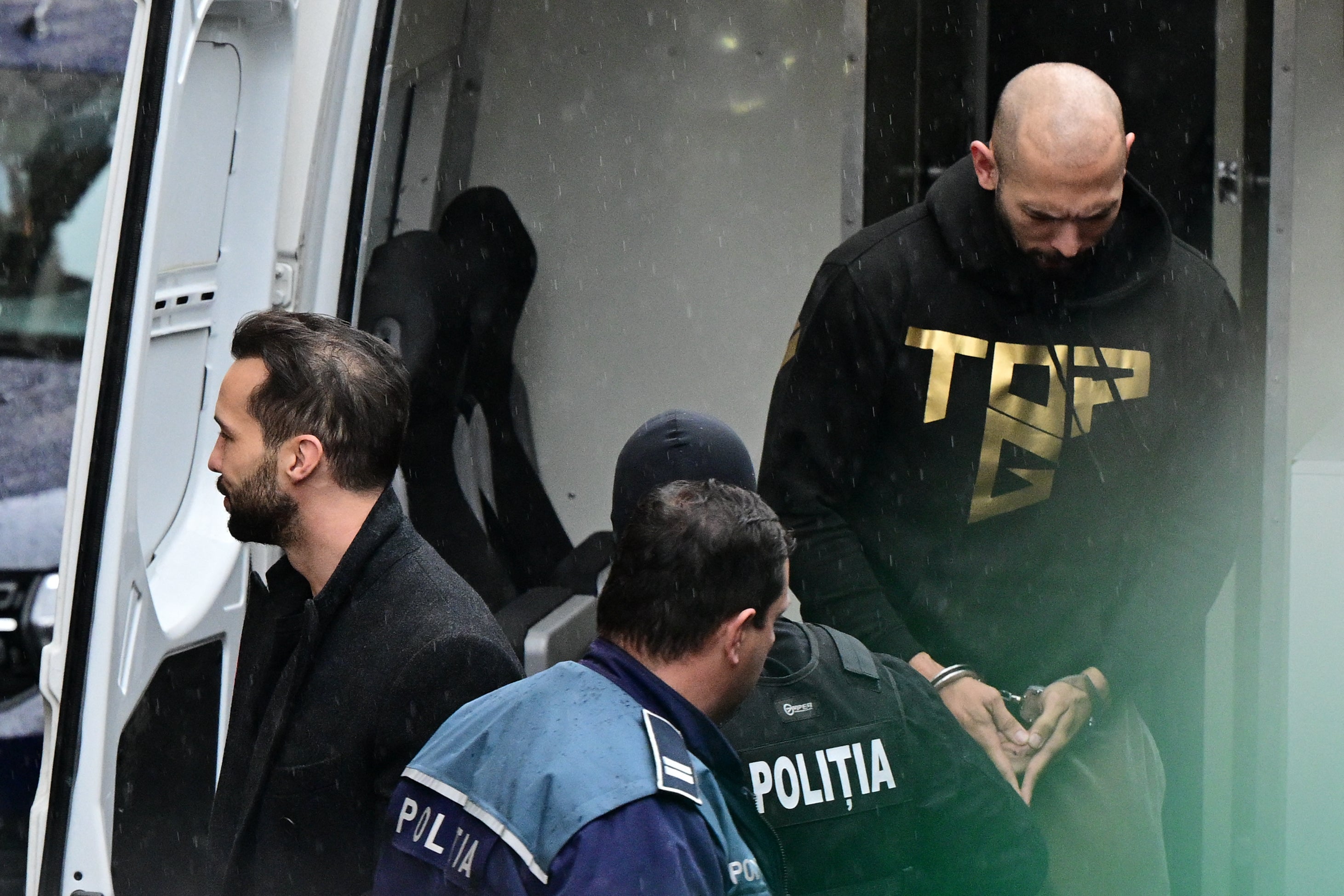 Andrew Tate and his brother being escorted into the court hearing