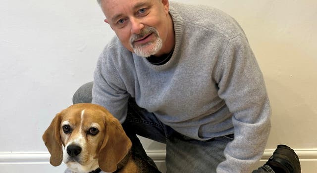 <p>Brian Flynn with Flash the Beagle at home in Faversham, Kent</p>