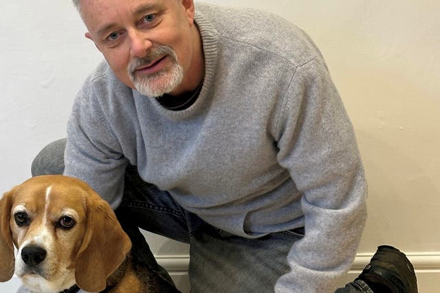<p>Brian Flynn with Flash the Beagle at home in Faversham, Kent</p>