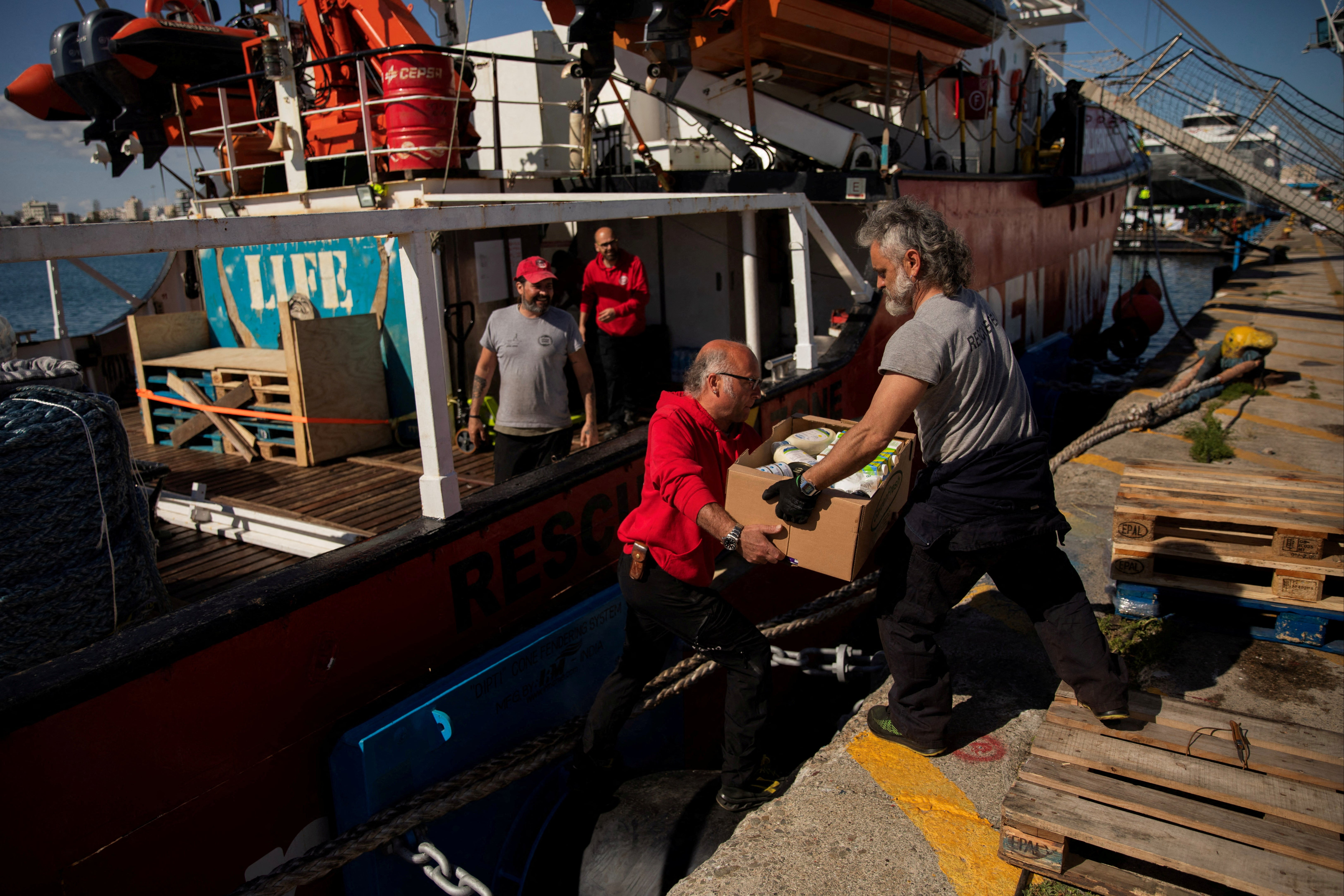 Open Arms members carry humanitarian aid for Gaza in a joint mission between the NGO and World Central Kitchen in the port of Larnaca