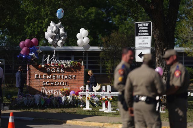 <p>Police officers stand next to a makeshift memorial outside the Robb Elementary School on May 26, 2022 in Uvalde, Texas.</p>