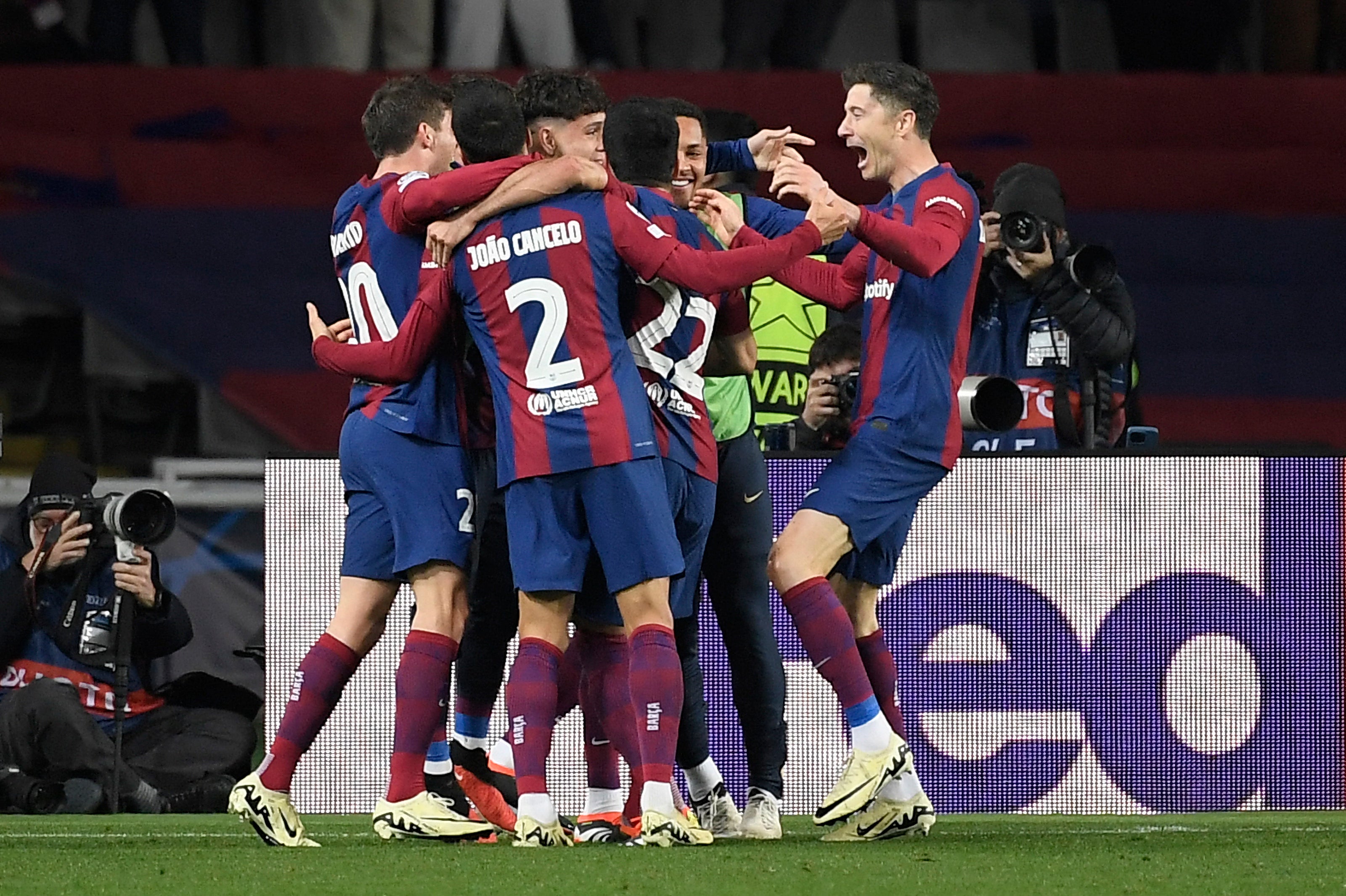 Barcelona players celebrate their third goal scored by Lewandowski, right