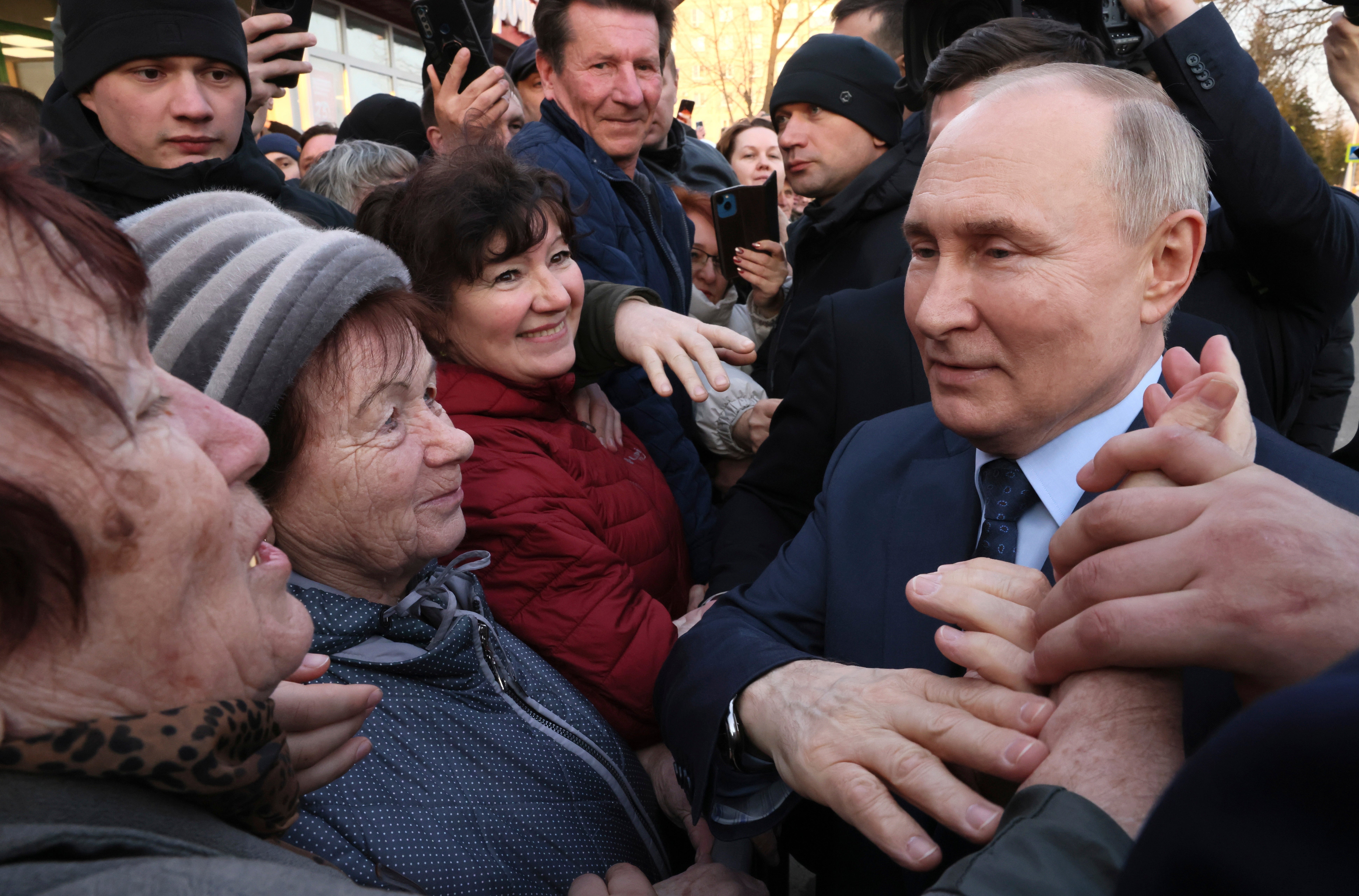 Russian president Vladimir Putin meets with residents following a visit to a greenhouse complex near Moscow ahead of elections this weekend